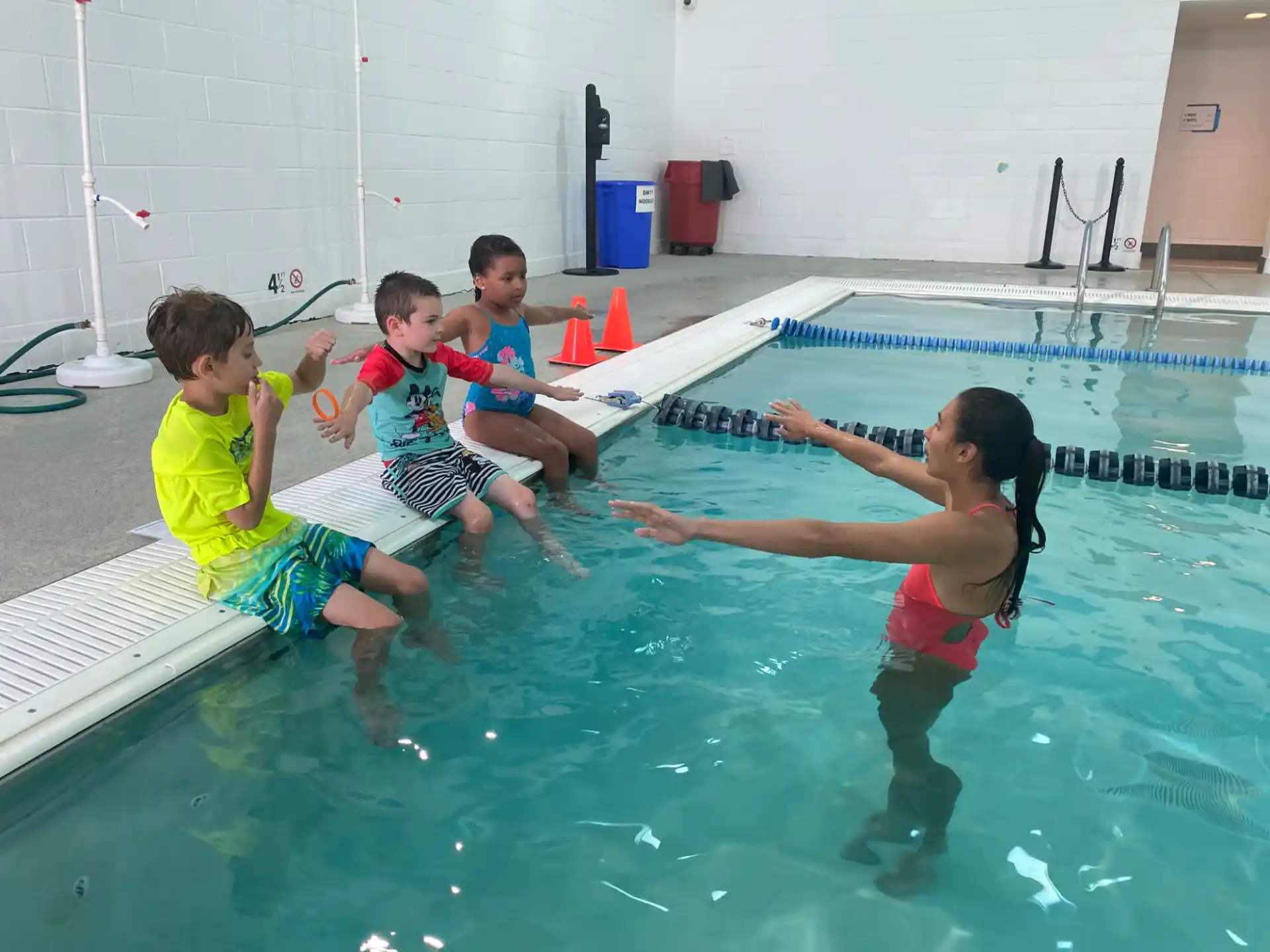 a group of kids playing in a pool