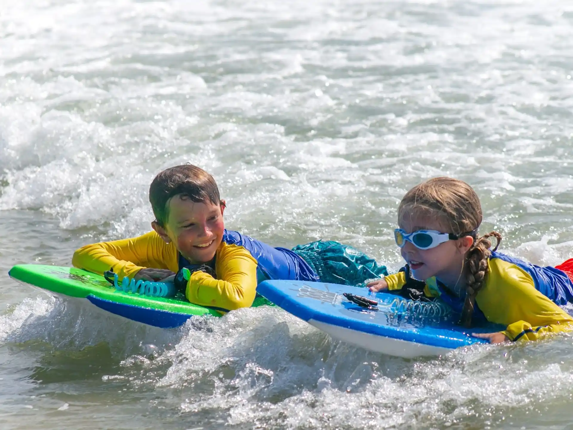 a man and a woman on a surfboard in the water