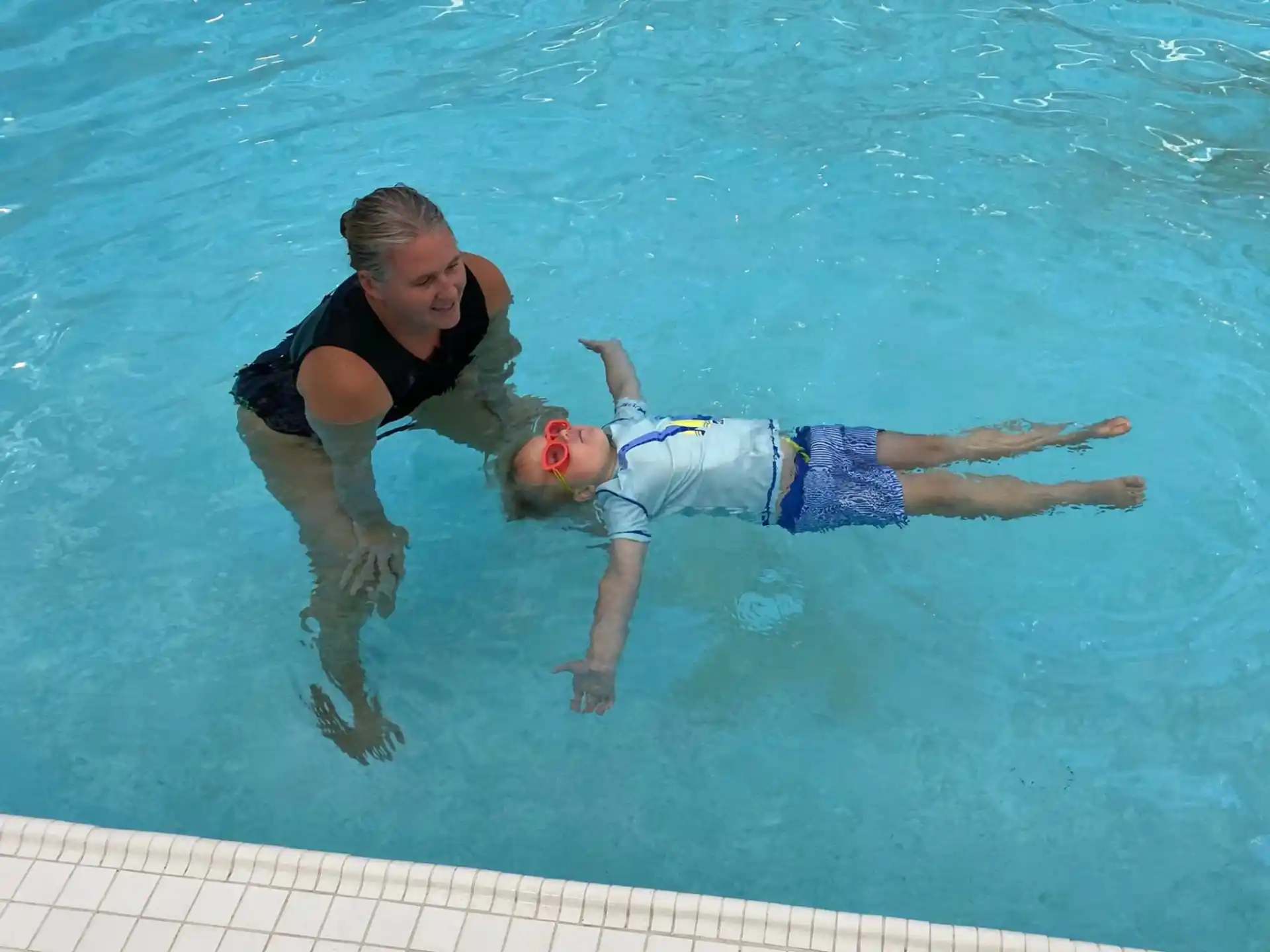 a man and a boy in a pool