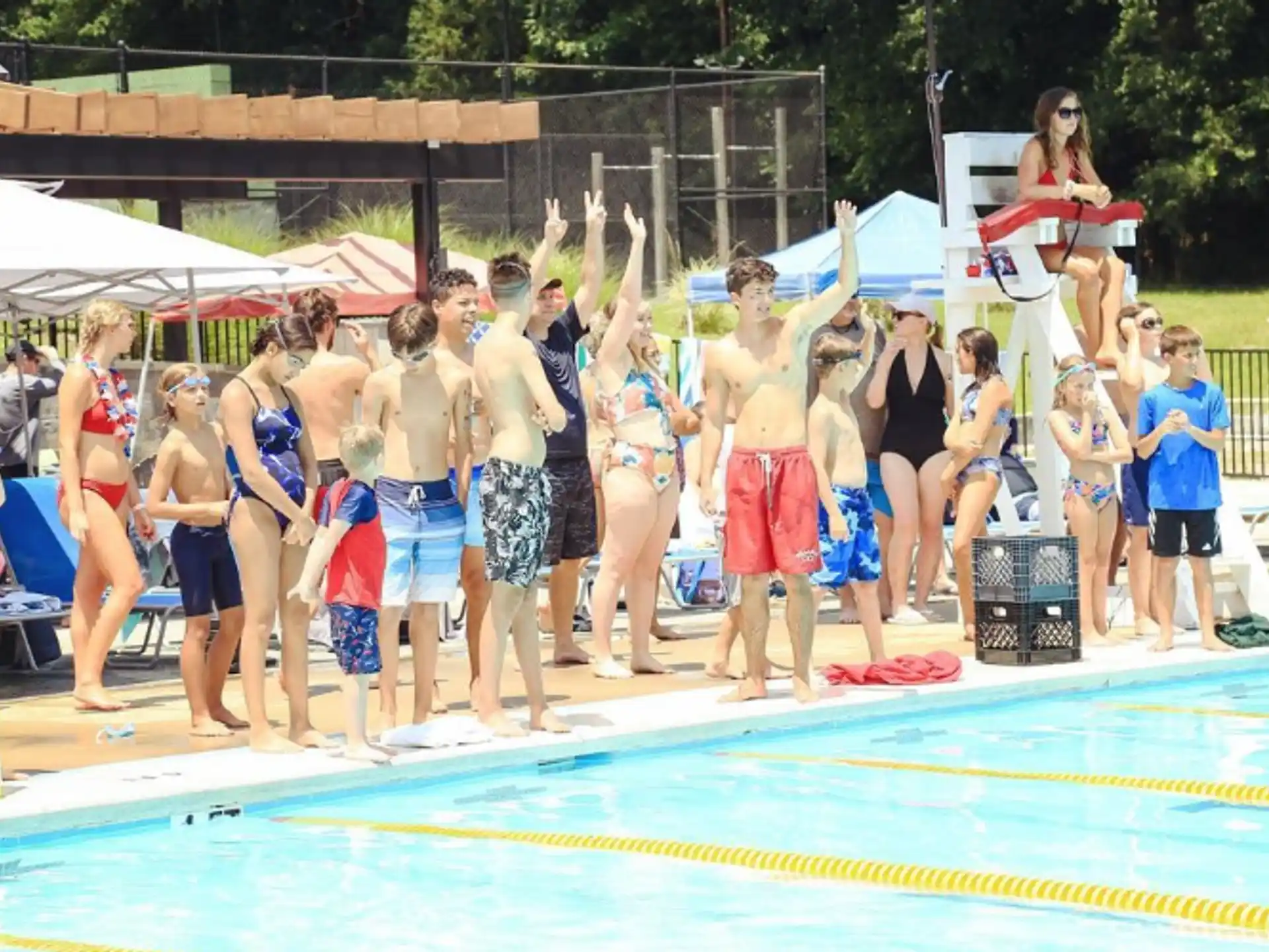 a group of people standing around a pool