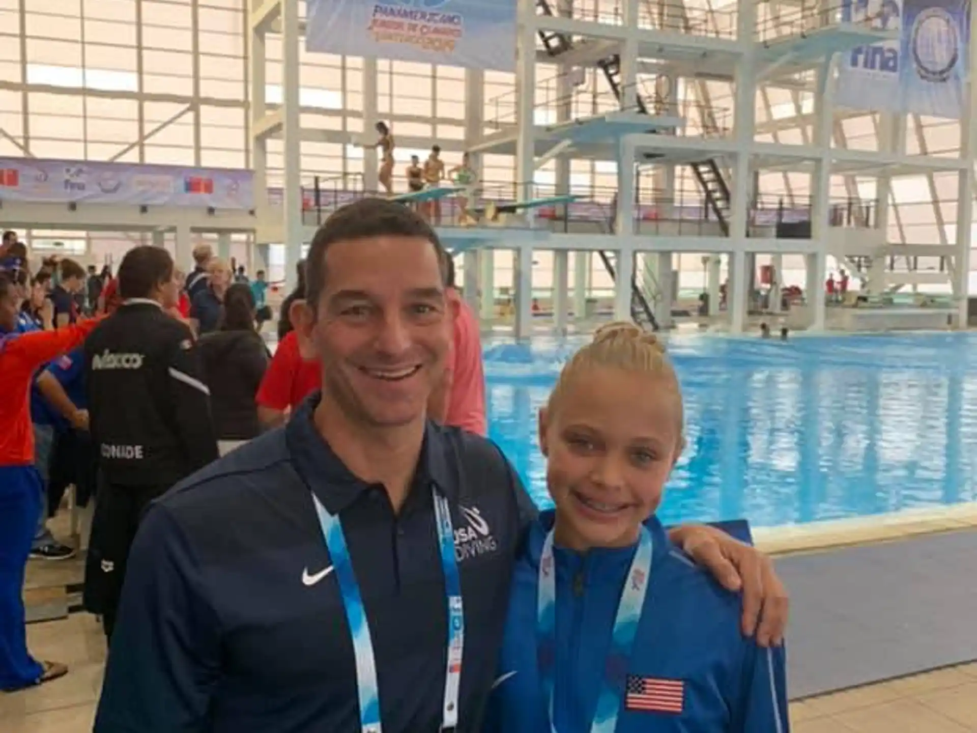 a person and a boy posing for a picture next to a pool