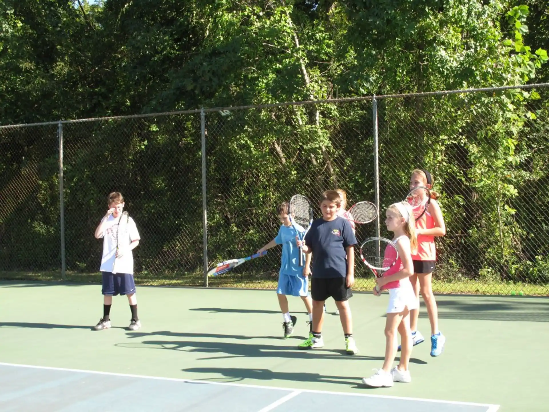 a group of kids holding tennis rackets