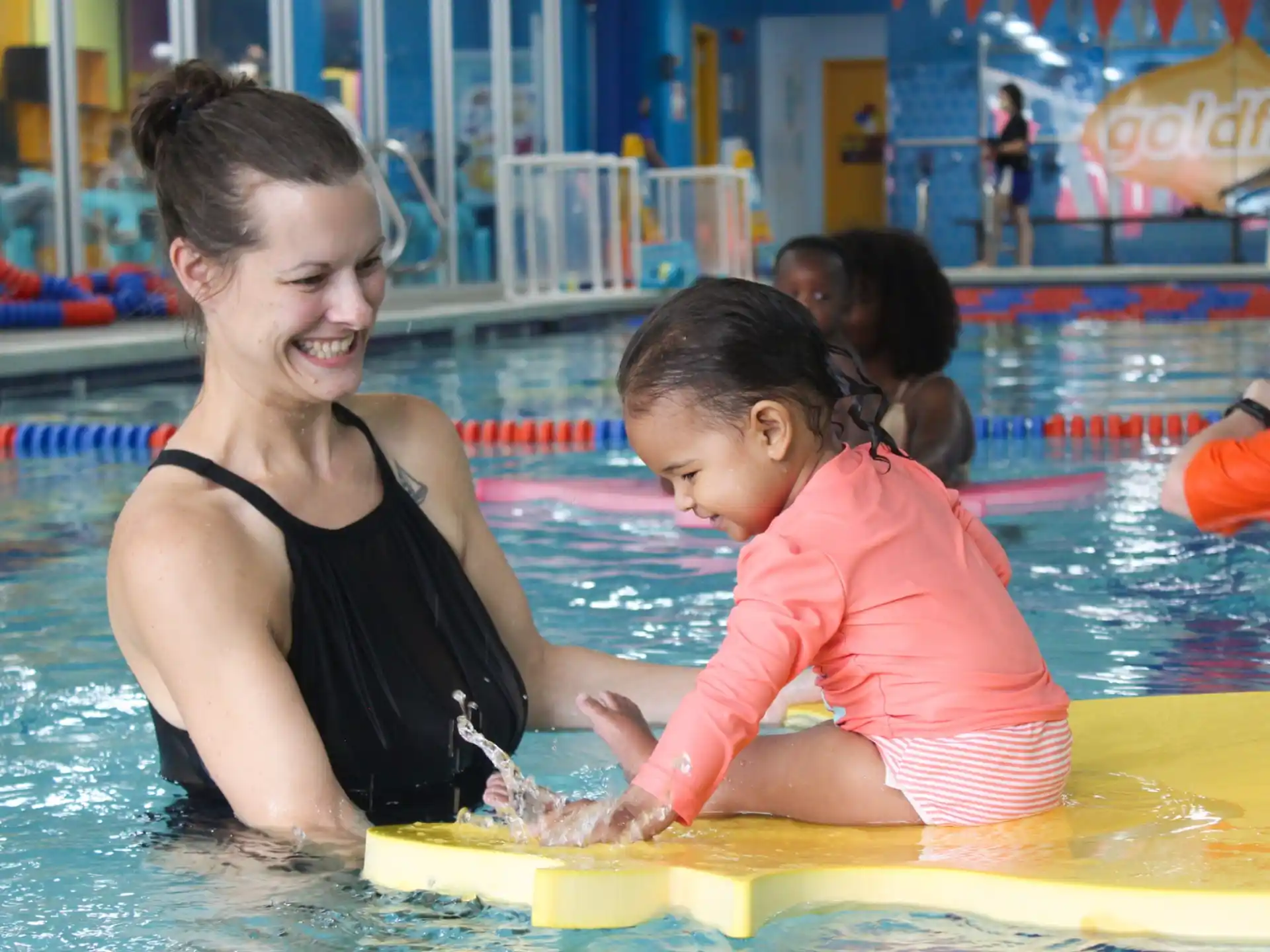 a woman and a couple of children in a pool