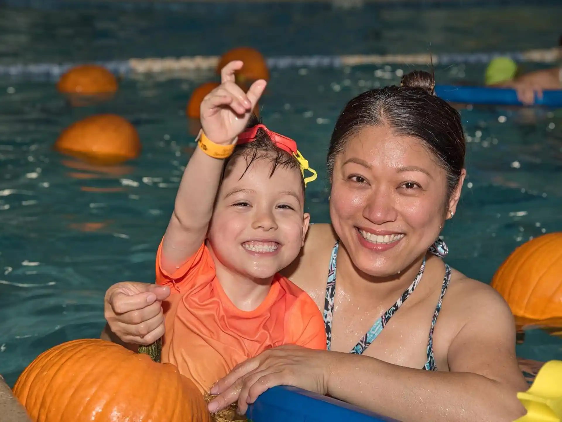 a person and a child in a pool with a floaty