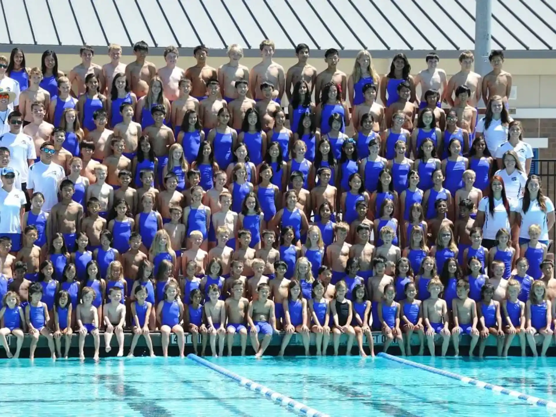 a group of people posing for a photo in a swimming pool