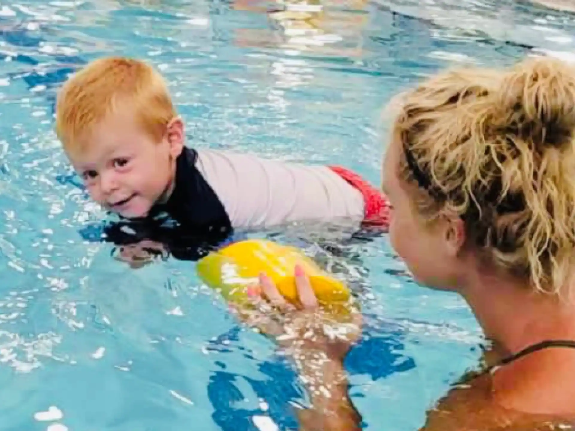 a person and a baby in a pool