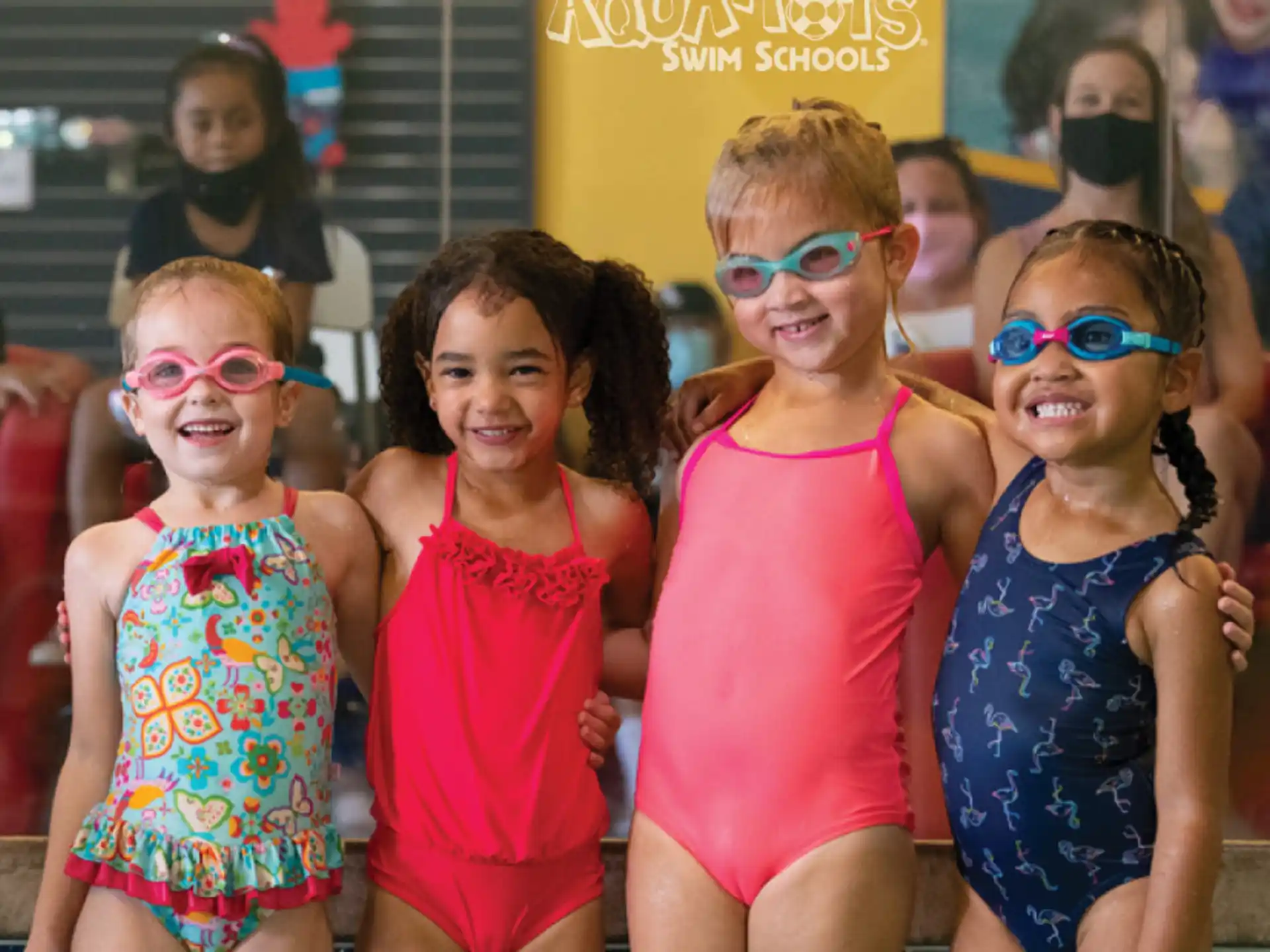 a group of children wearing swimsuits and posing for a photo