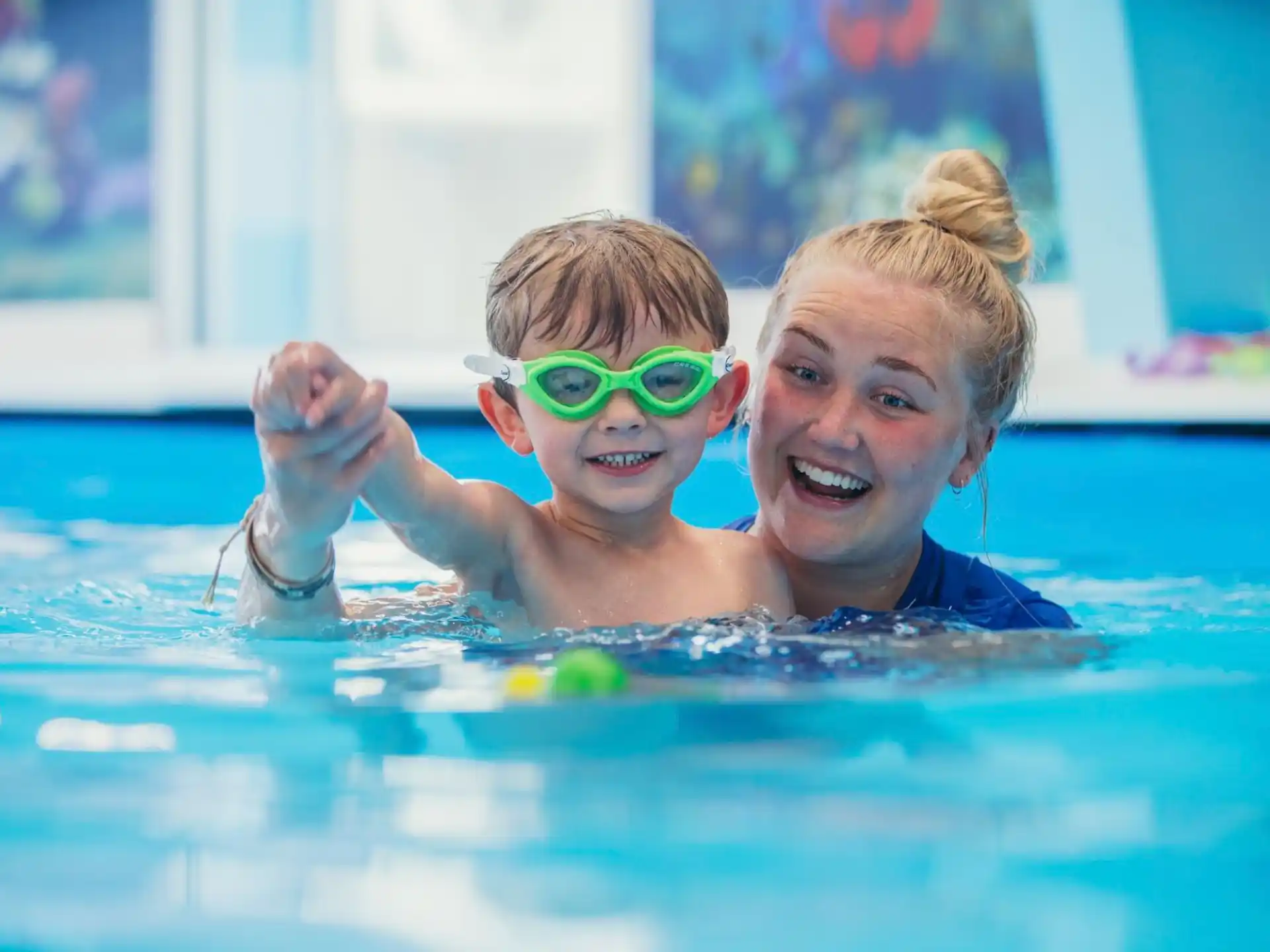 a couple of girls in a pool wearing goggles