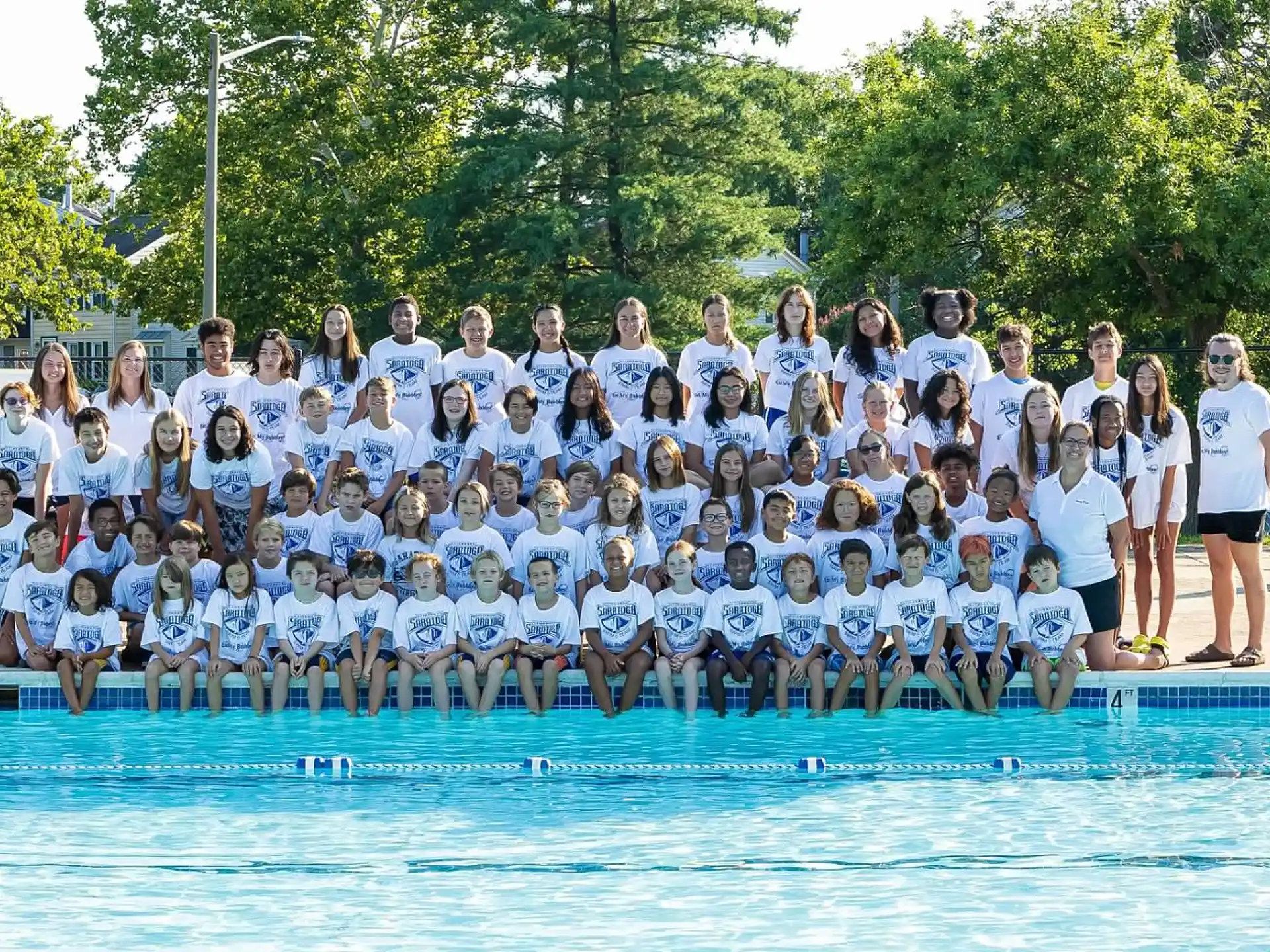 a group of people posing for a photo in front of a pool