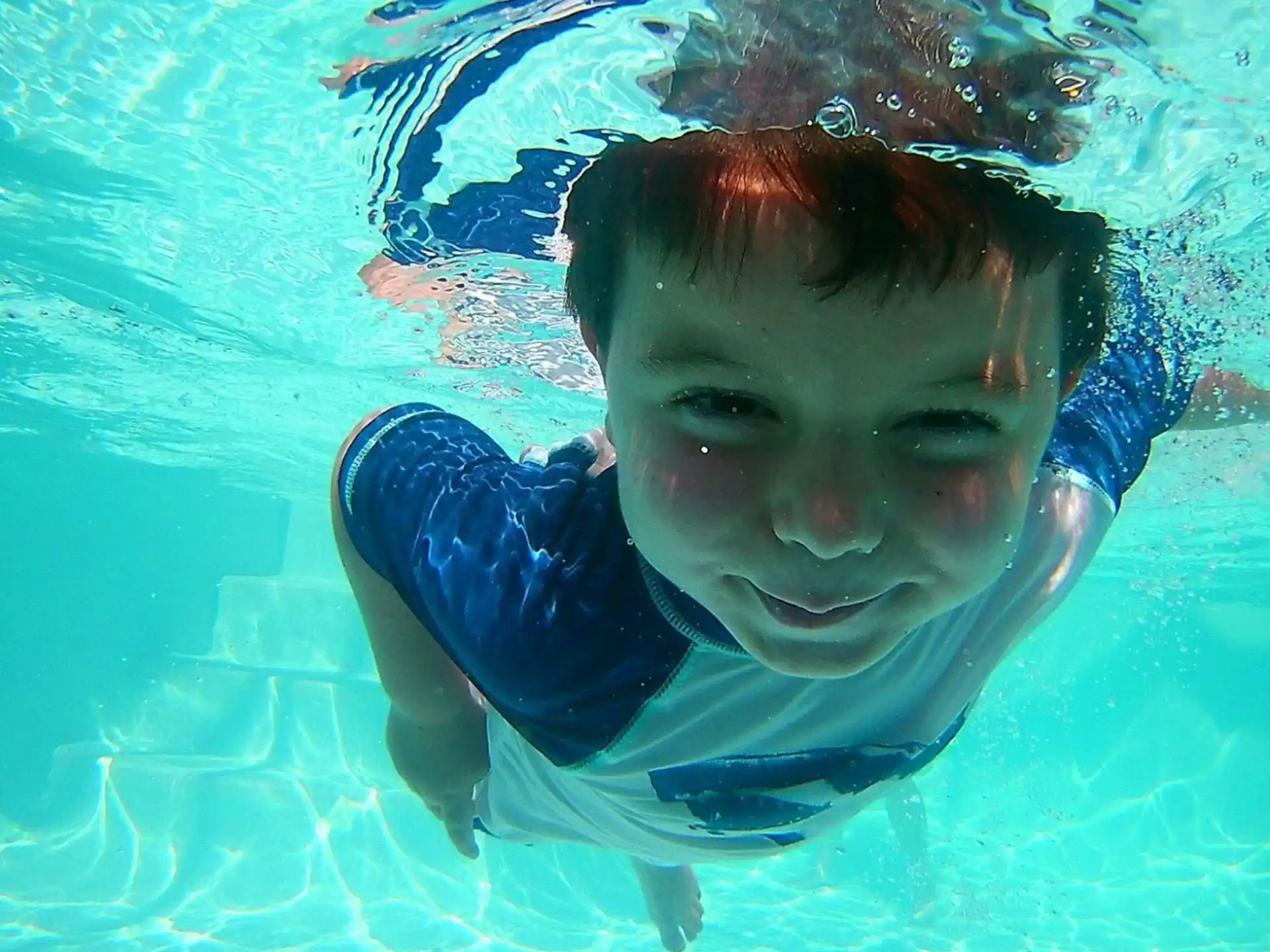 a boy swimming in a pool