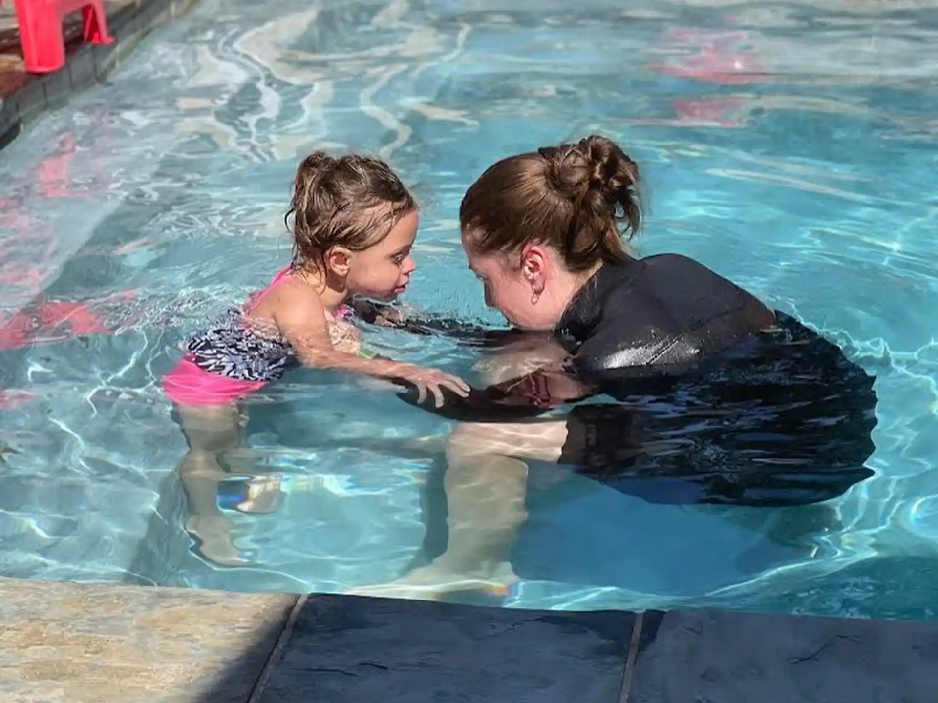 a person and a child in a pool