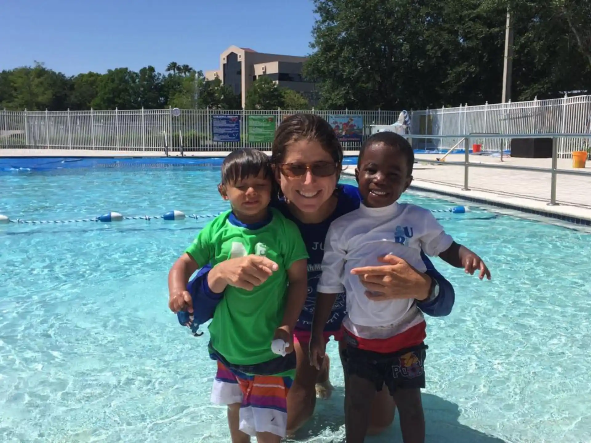 a group of kids posing for a picture in a pool