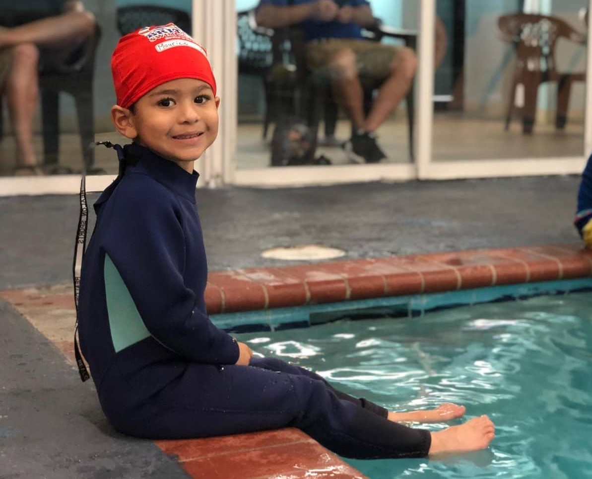 a boy sitting in a pool