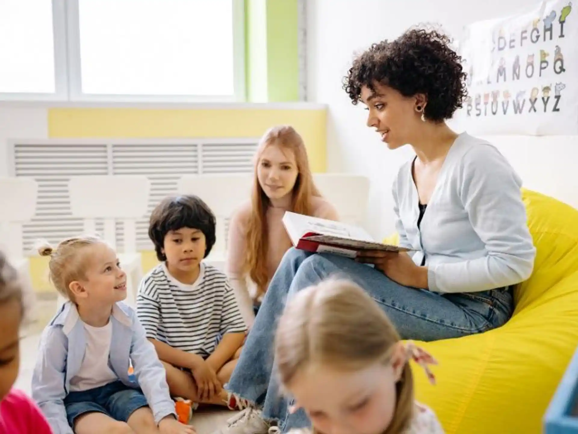 a person reading a book to a group of children