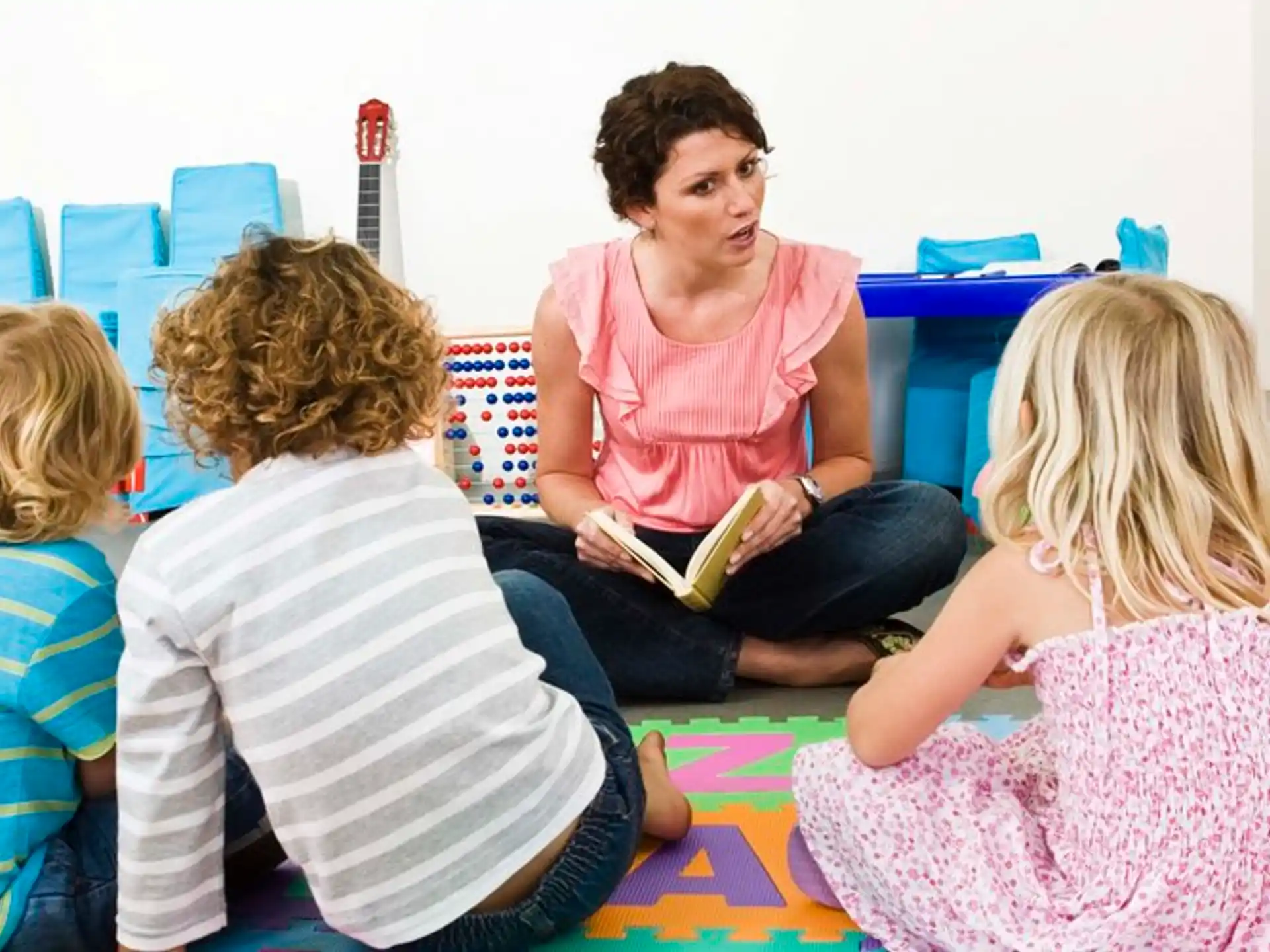 a person reading a book to a group of children