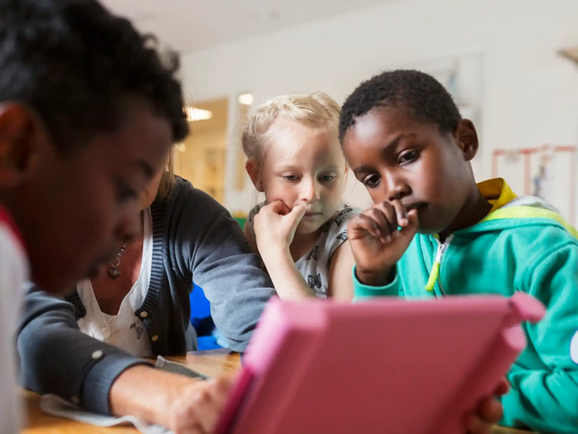 a group of young people looking at a laptop