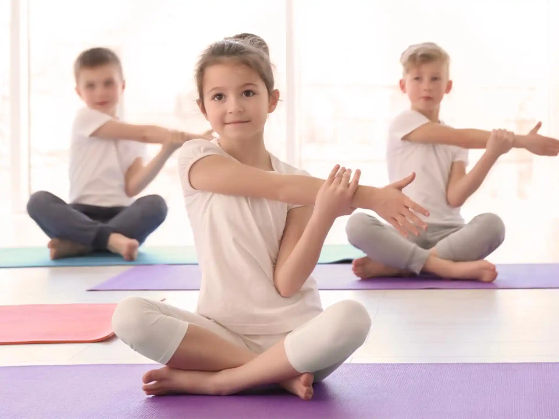 a few children sitting on mats