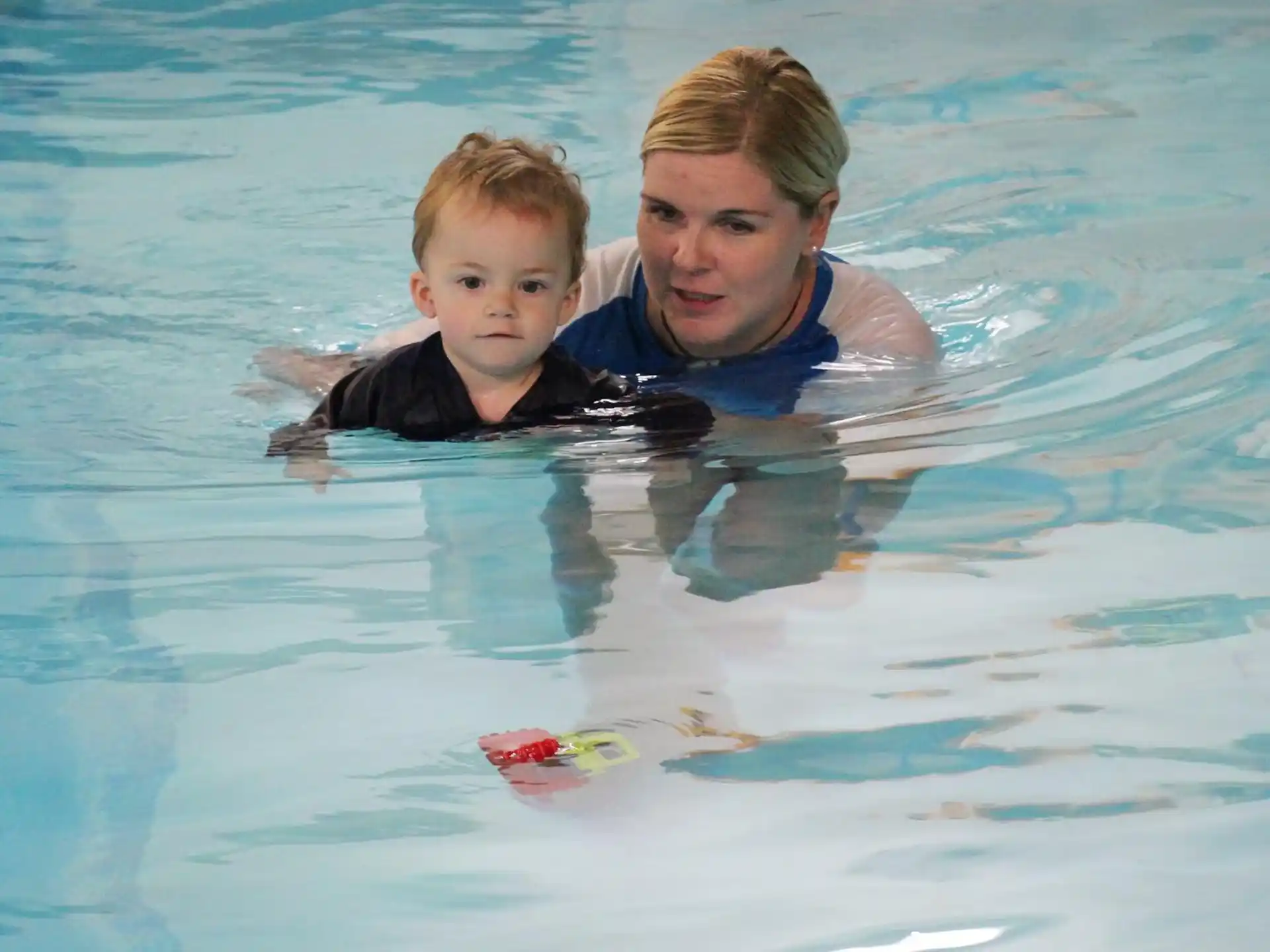 a person and two boys in a pool