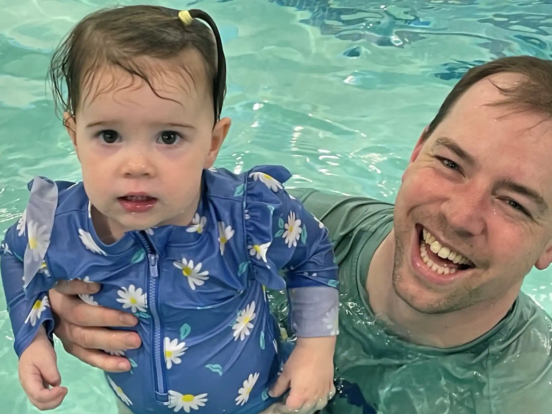 a man and a baby in a pool