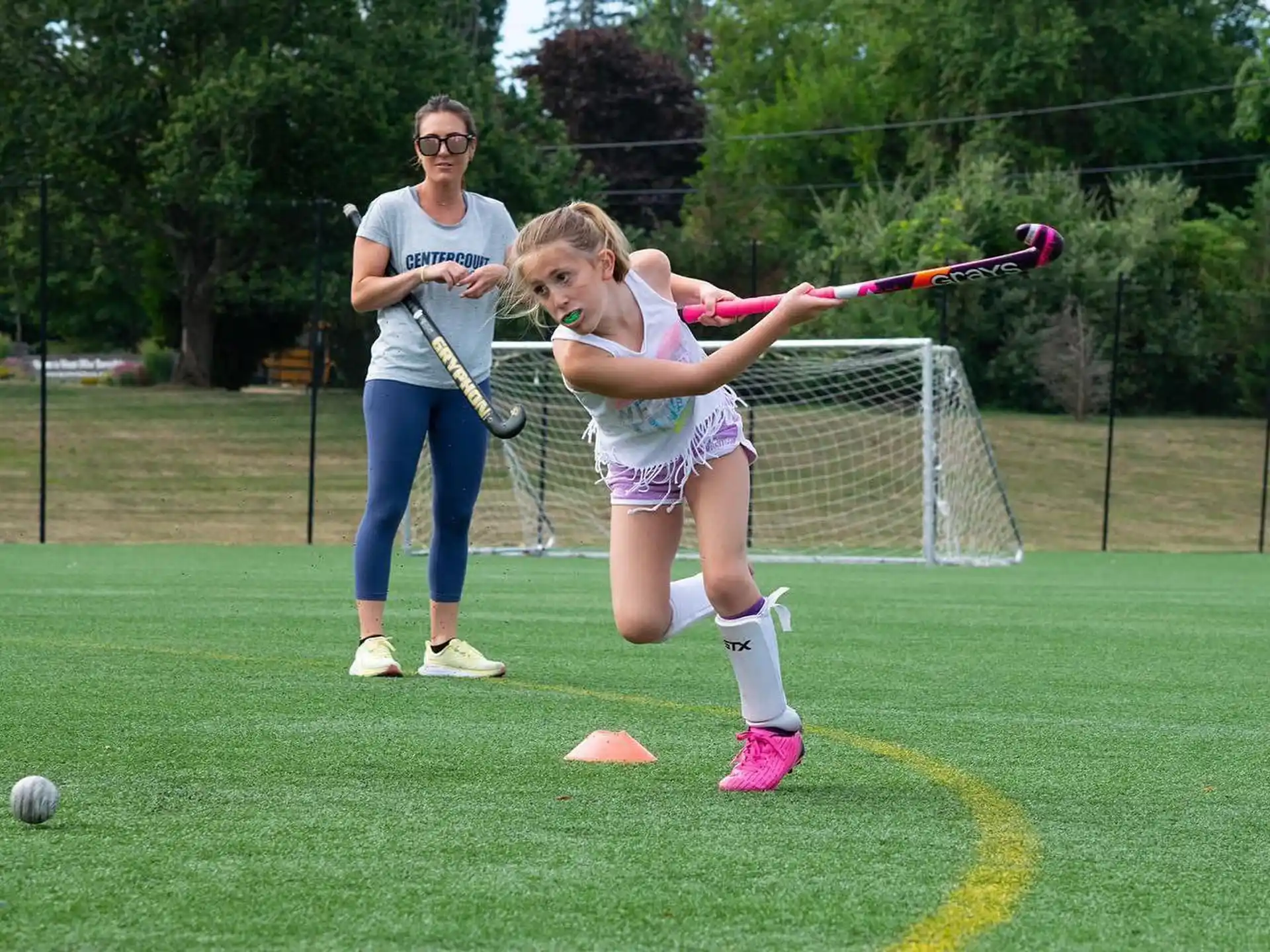 a person and a girl playing lacrosse