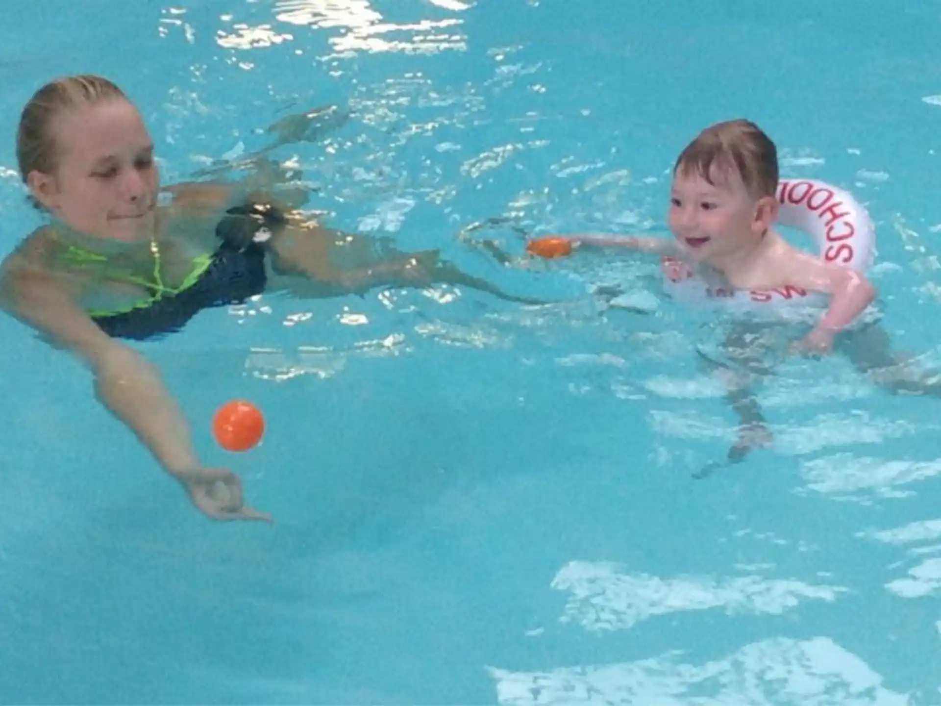 a couple of kids swimming in a pool