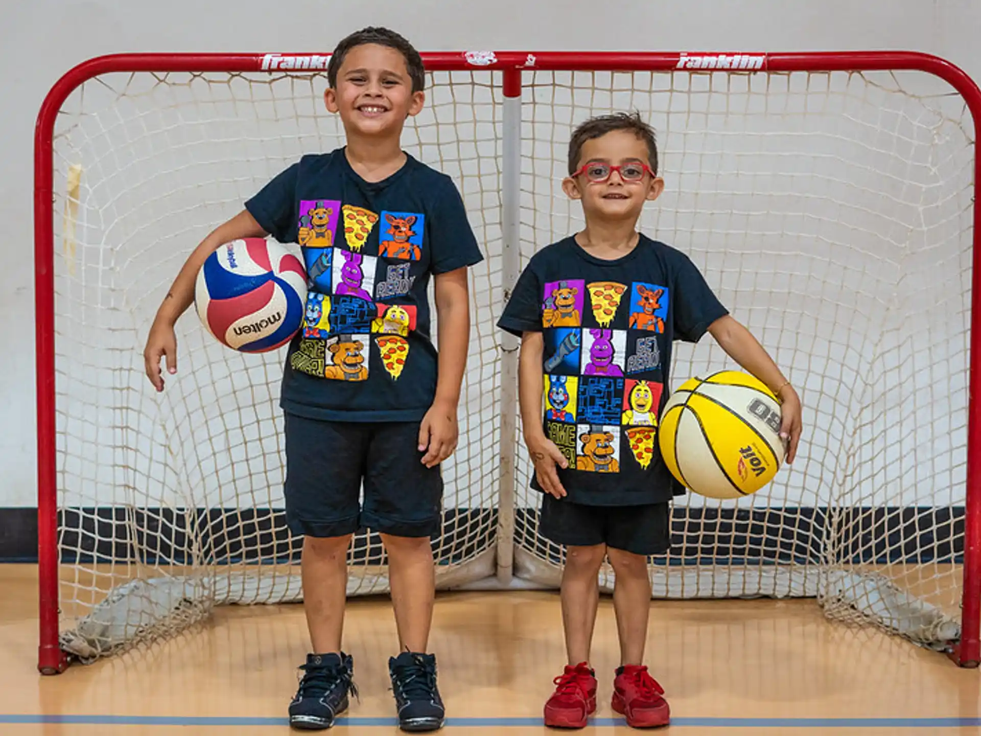 a couple of boys holding a ball