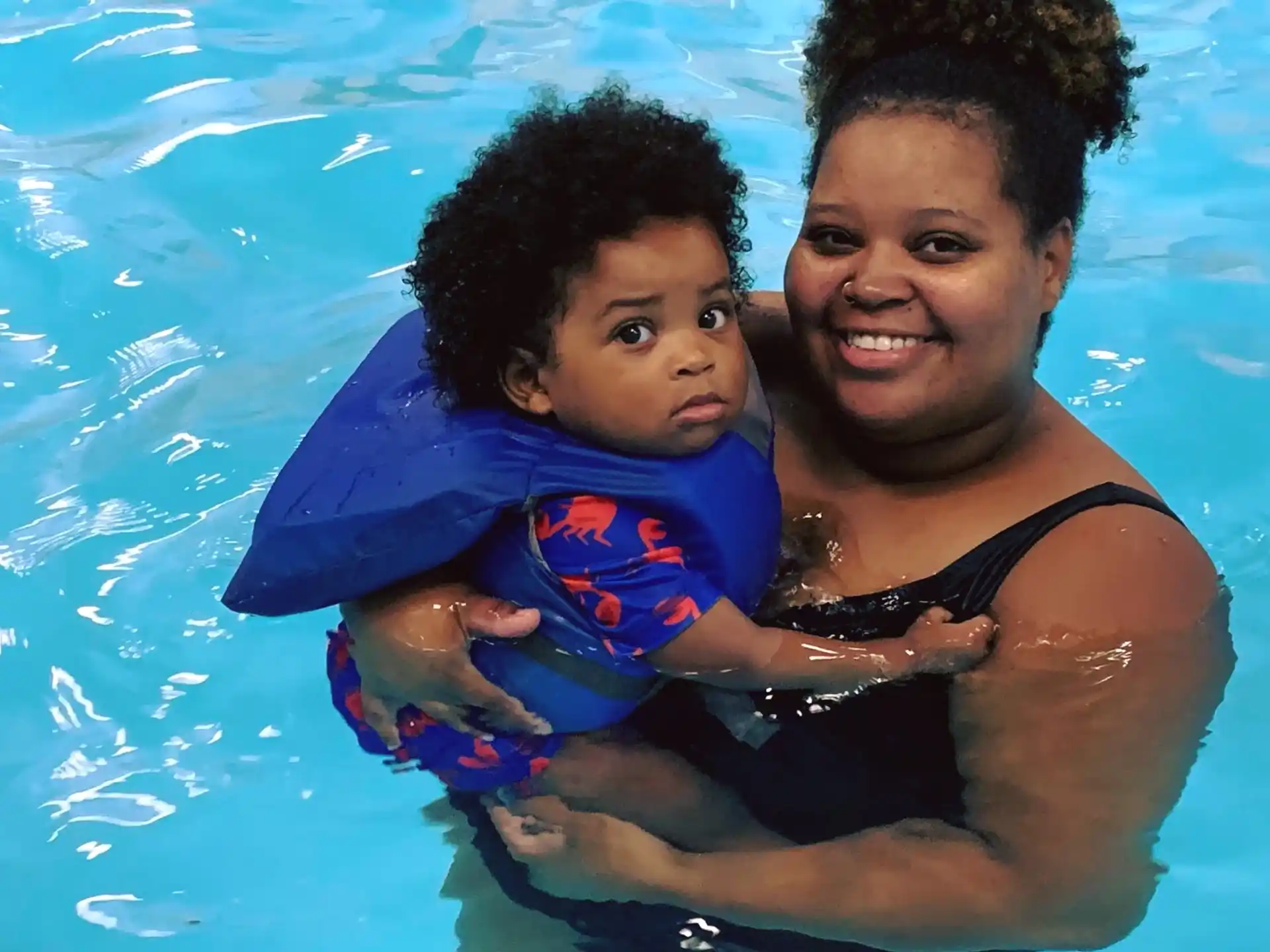 a person and a baby in a pool