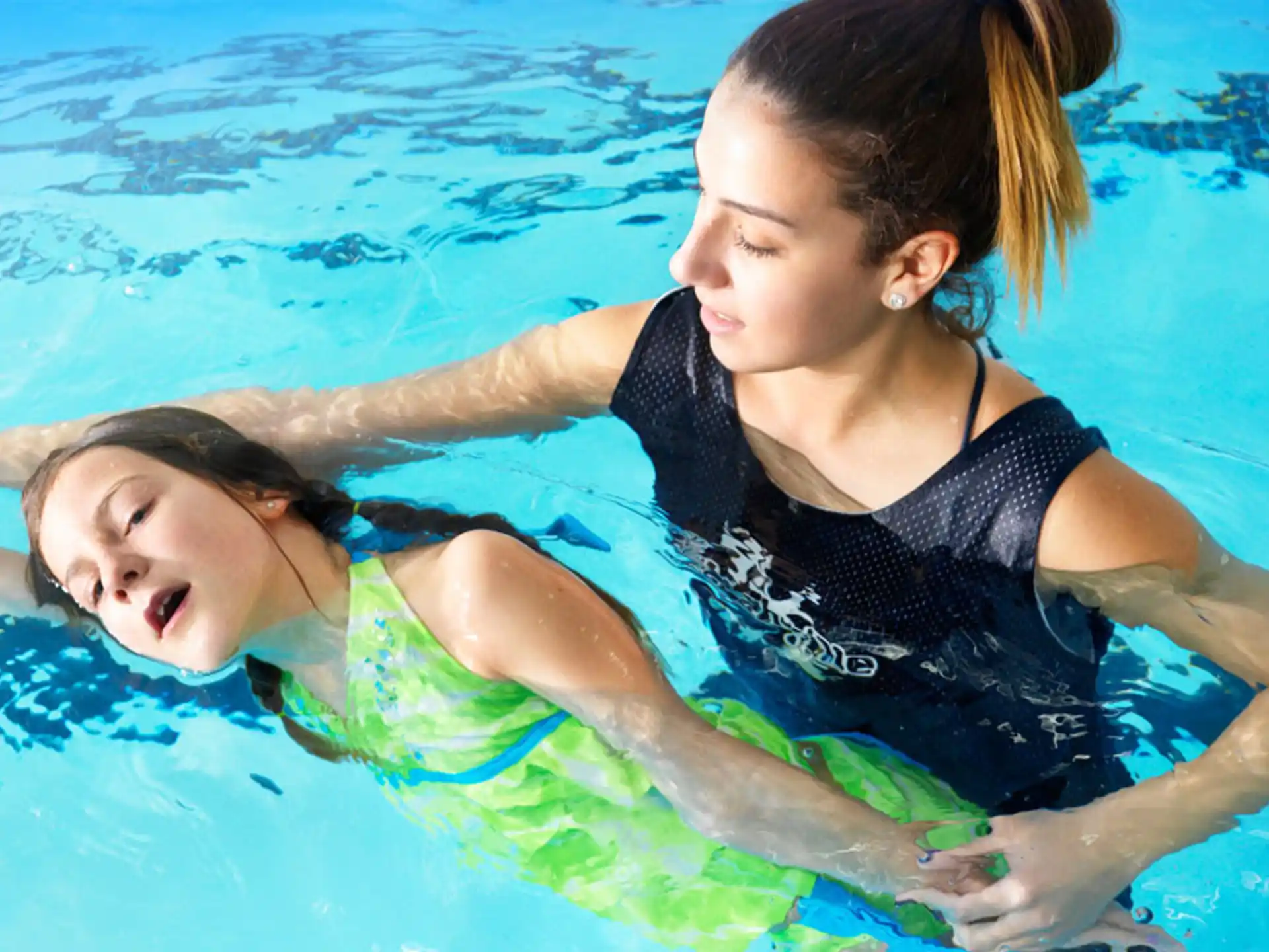 a woman and a girl in a pool