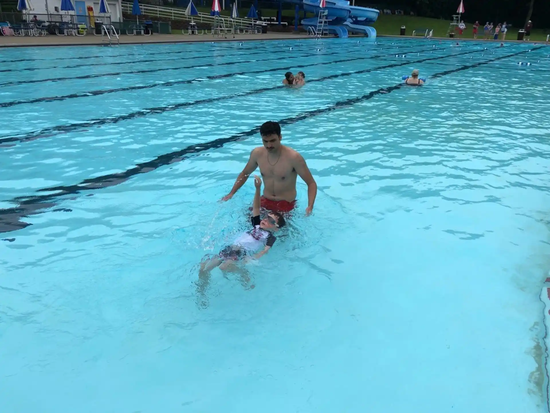 a man in a pool with a dolphin in it