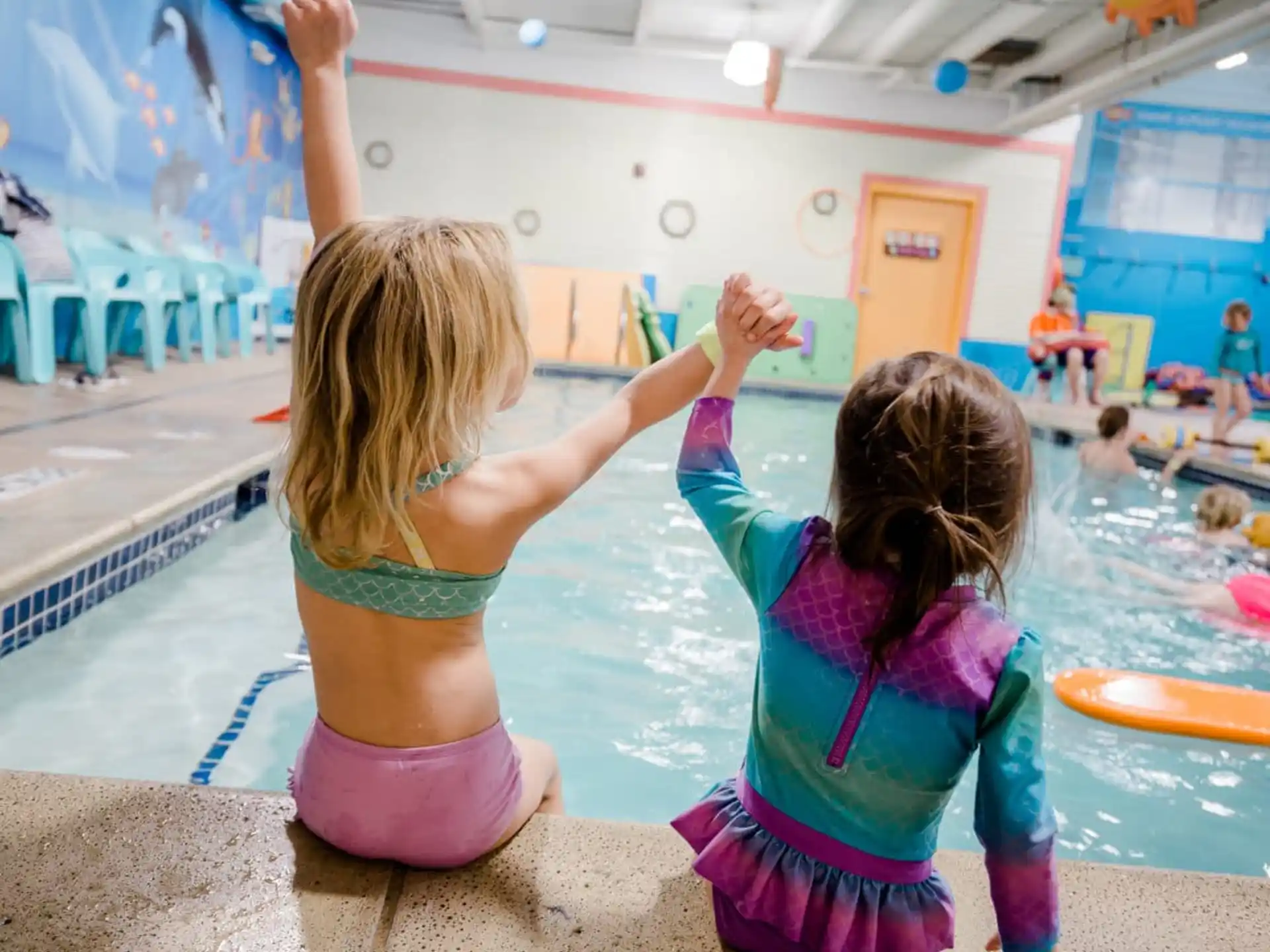 a couple of girls playing in a swimming pool