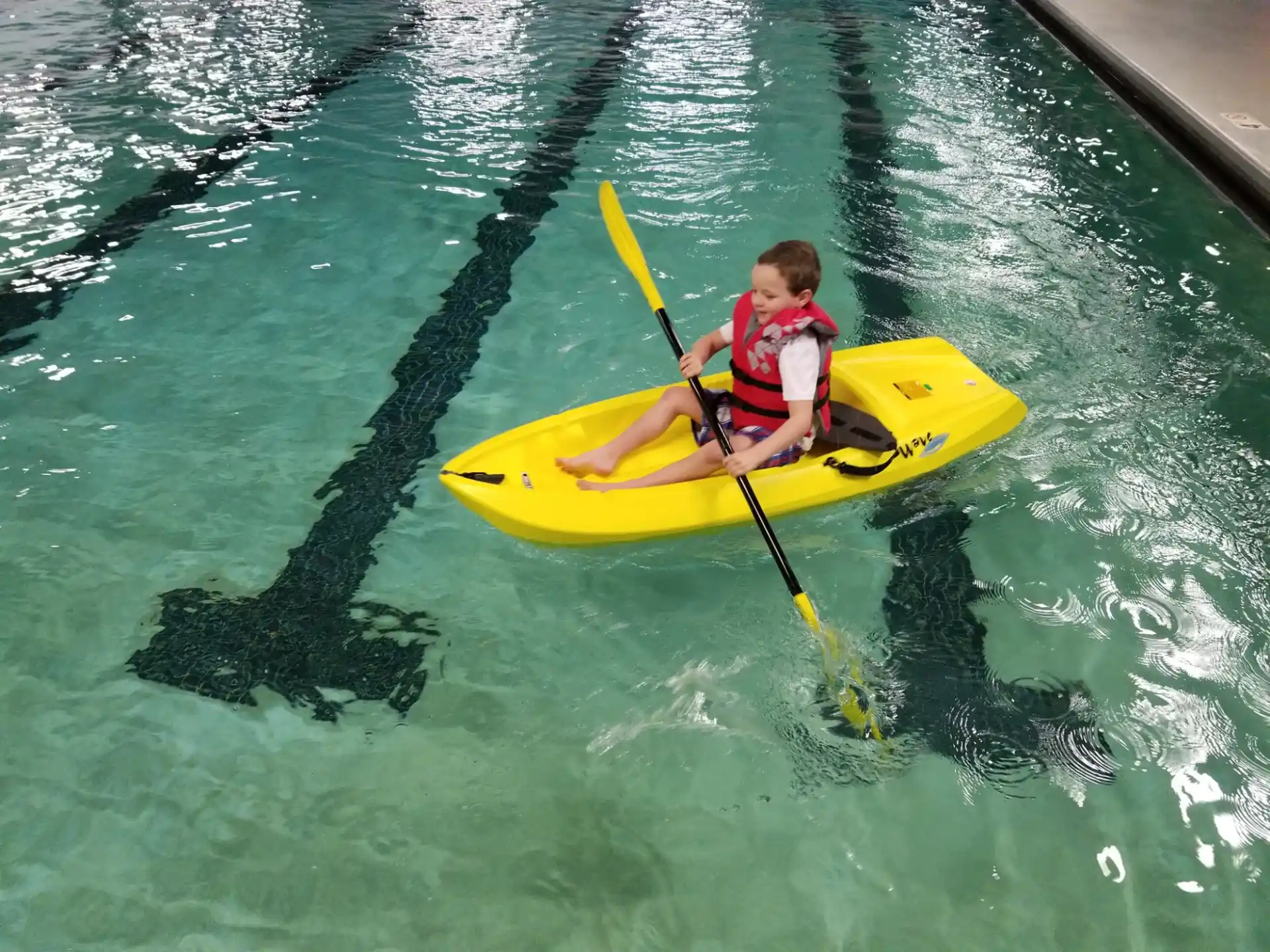 a boy in a yellow kayak