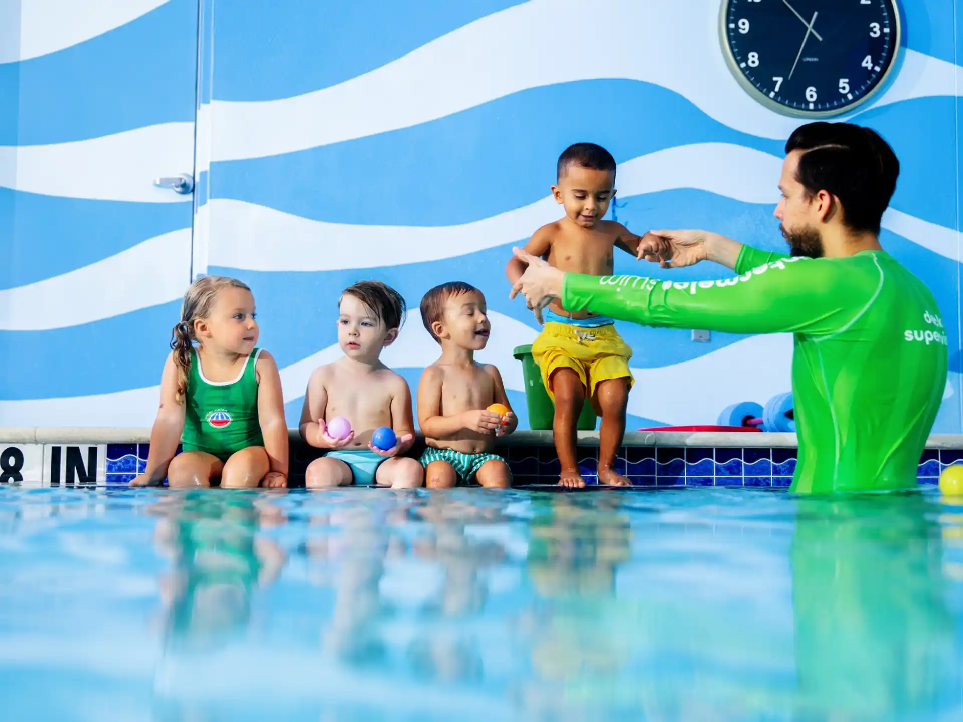 a person and a group of children in a pool