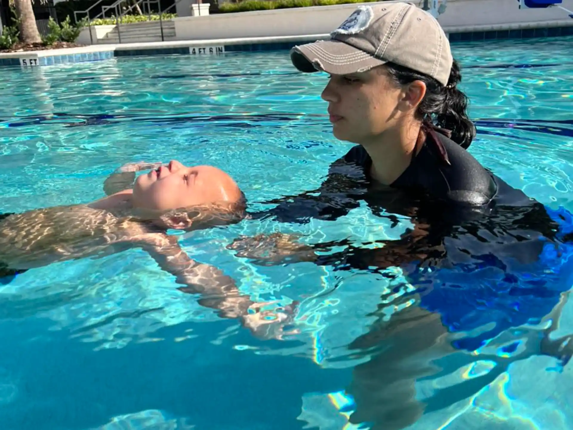 a person kissing a dolphin in a pool