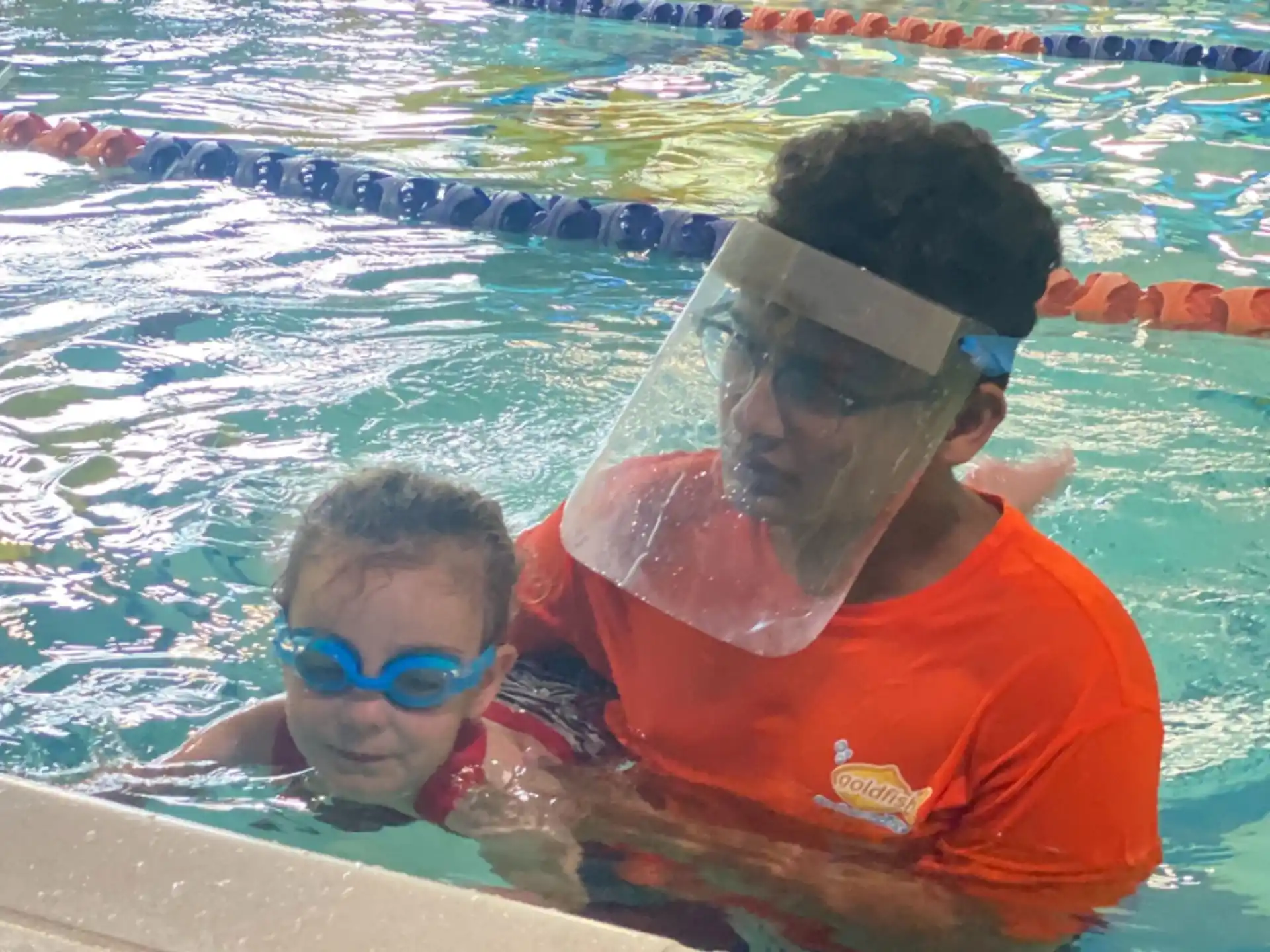 a man and a boy in a pool wearing goggles