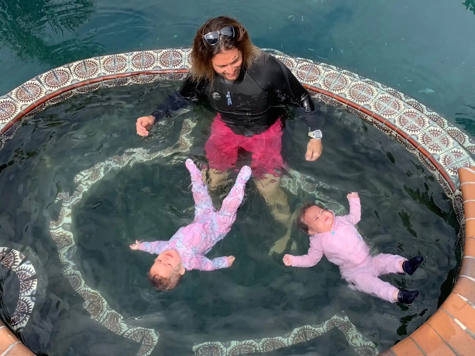 a person and two children in a pool