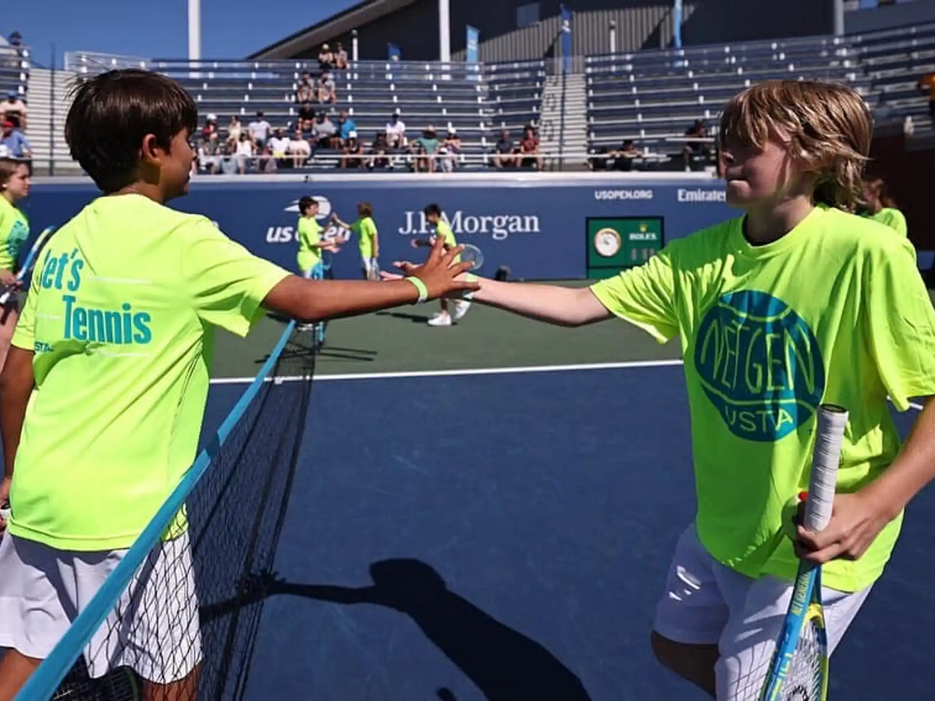 a couple of men holding tennis rackets on a court