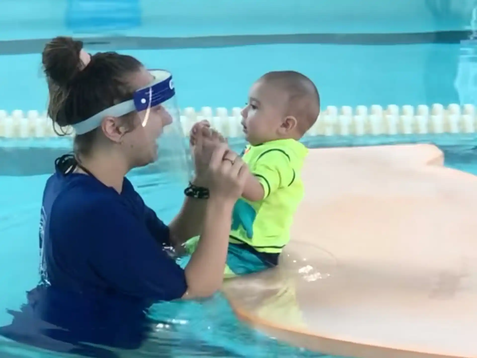 a person and a baby in a pool