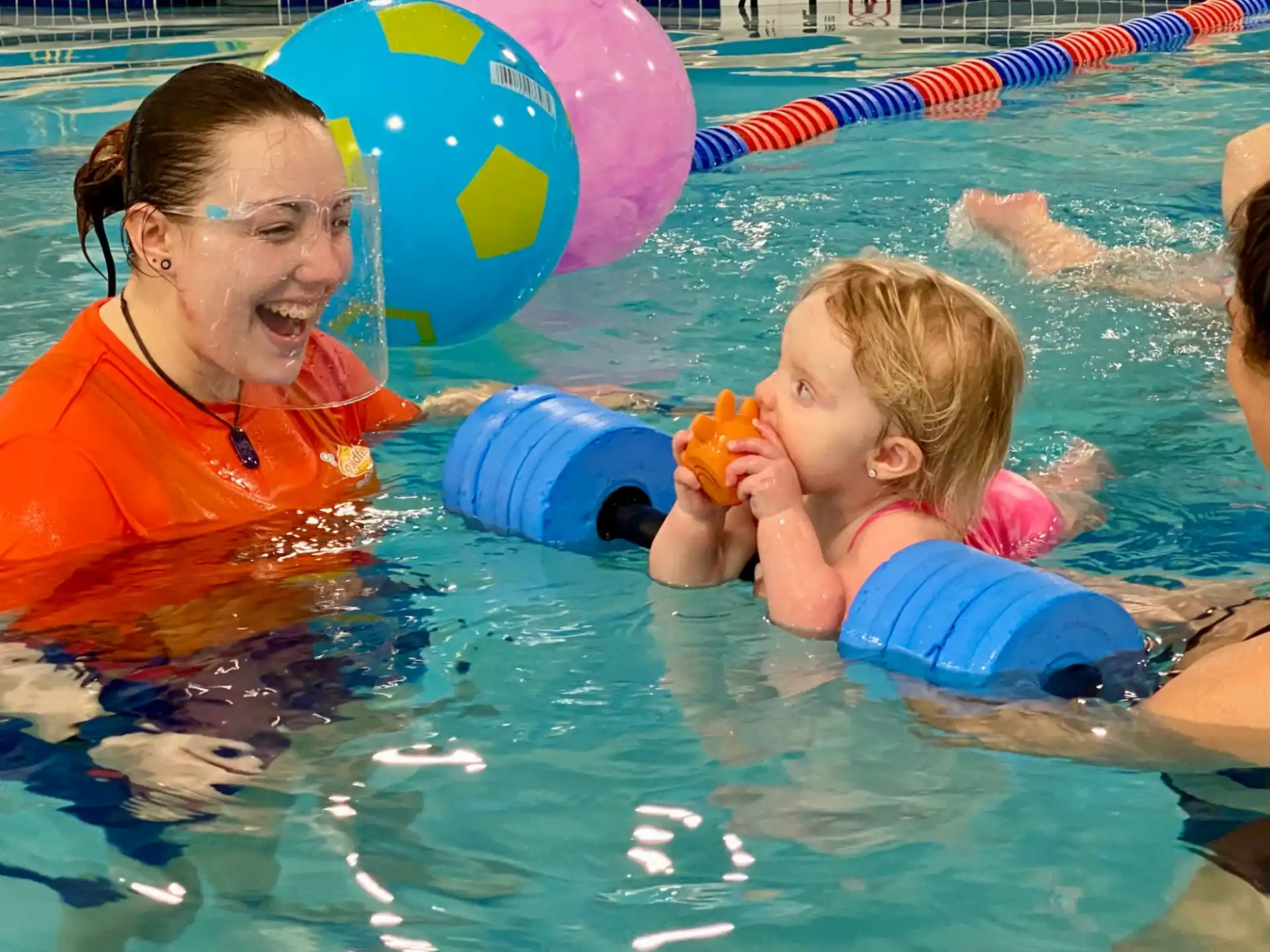 a man and a child in a pool with balloons