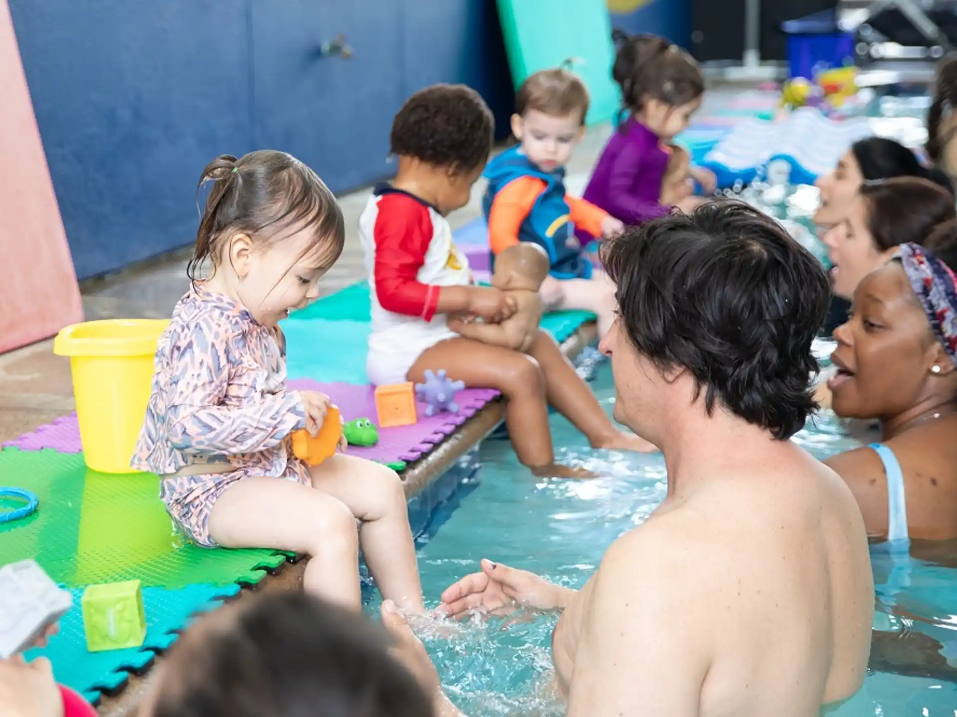 a group of children playing in a pool