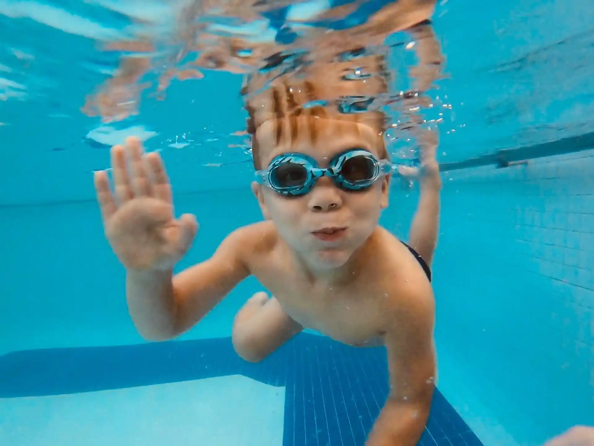 a child in a pool wearing goggles