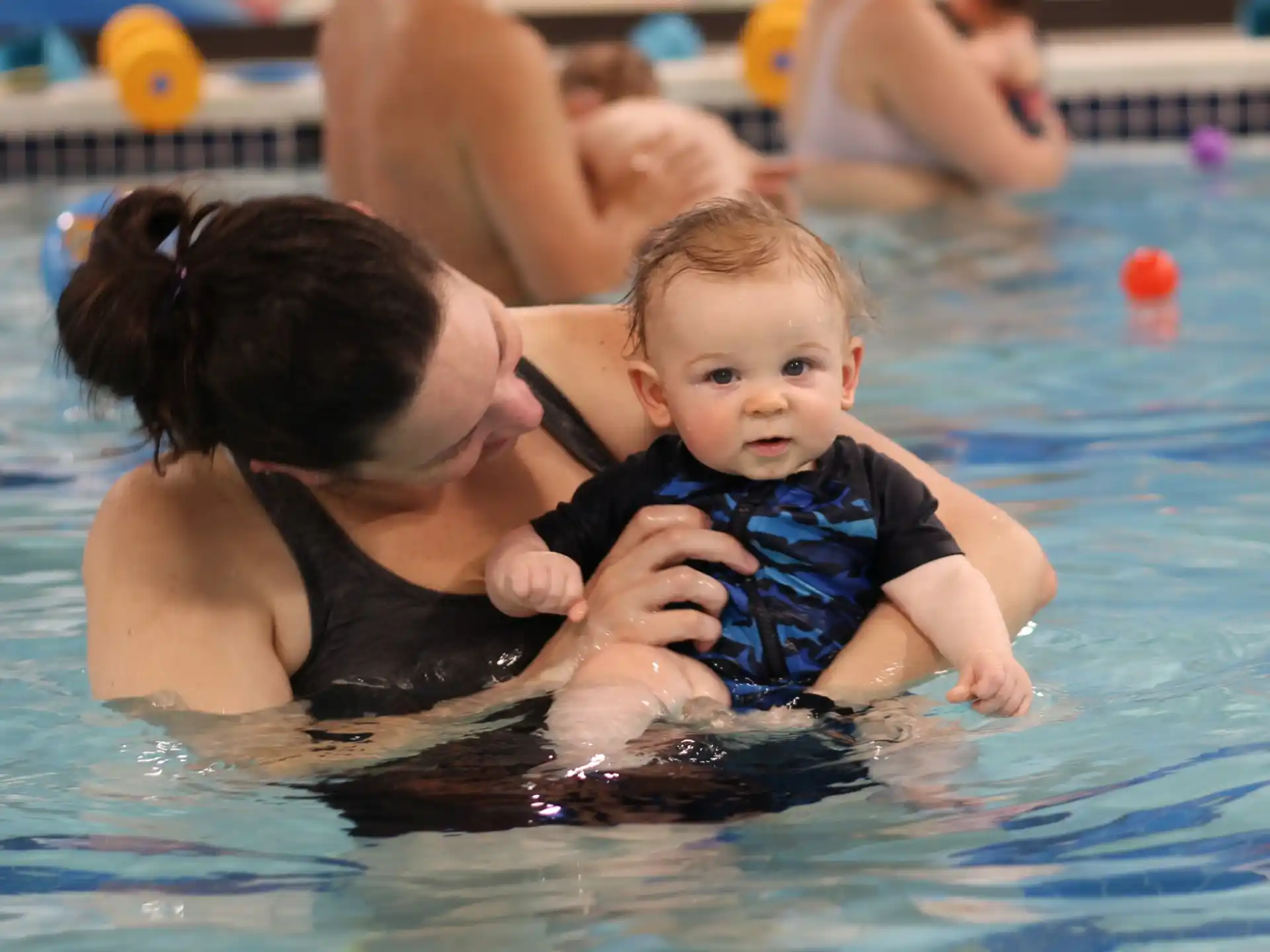 a person and a baby in a pool