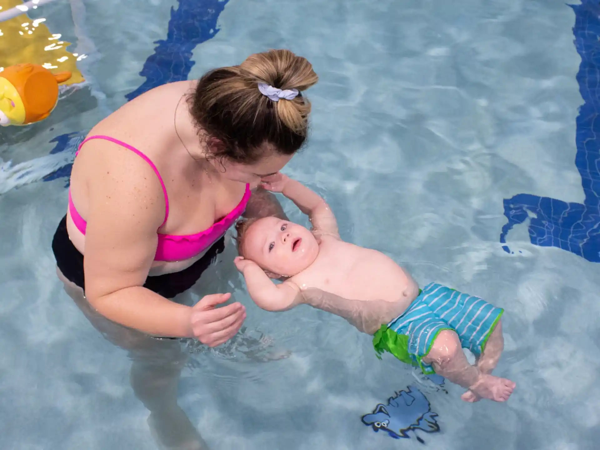 a person and a baby playing in a pool