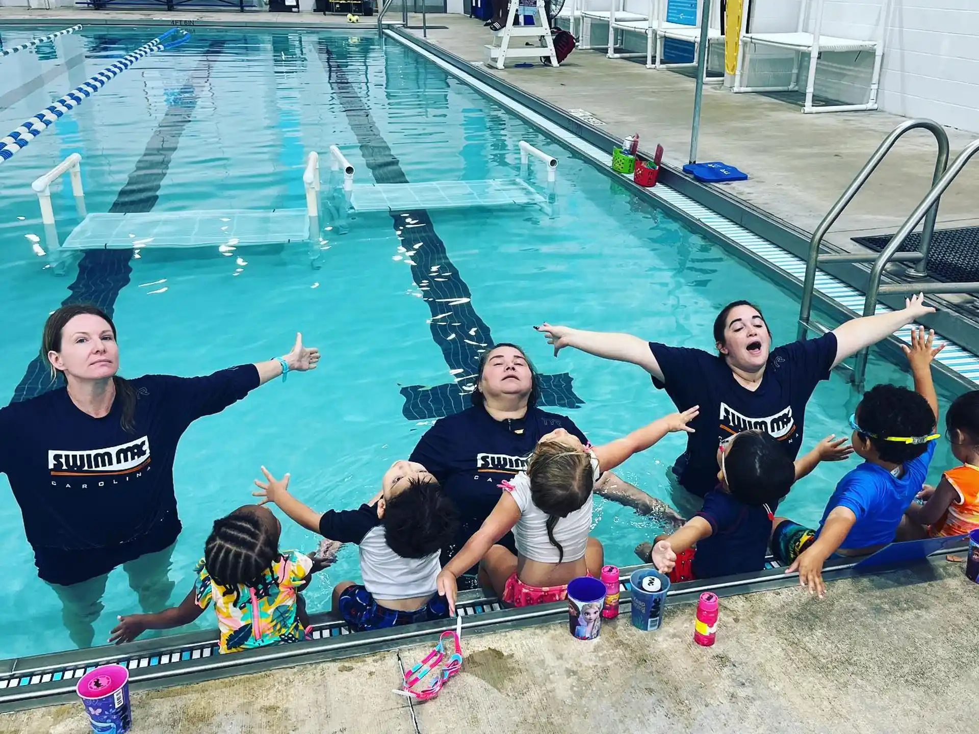 a group of people posing for a photo next to a swimming pool