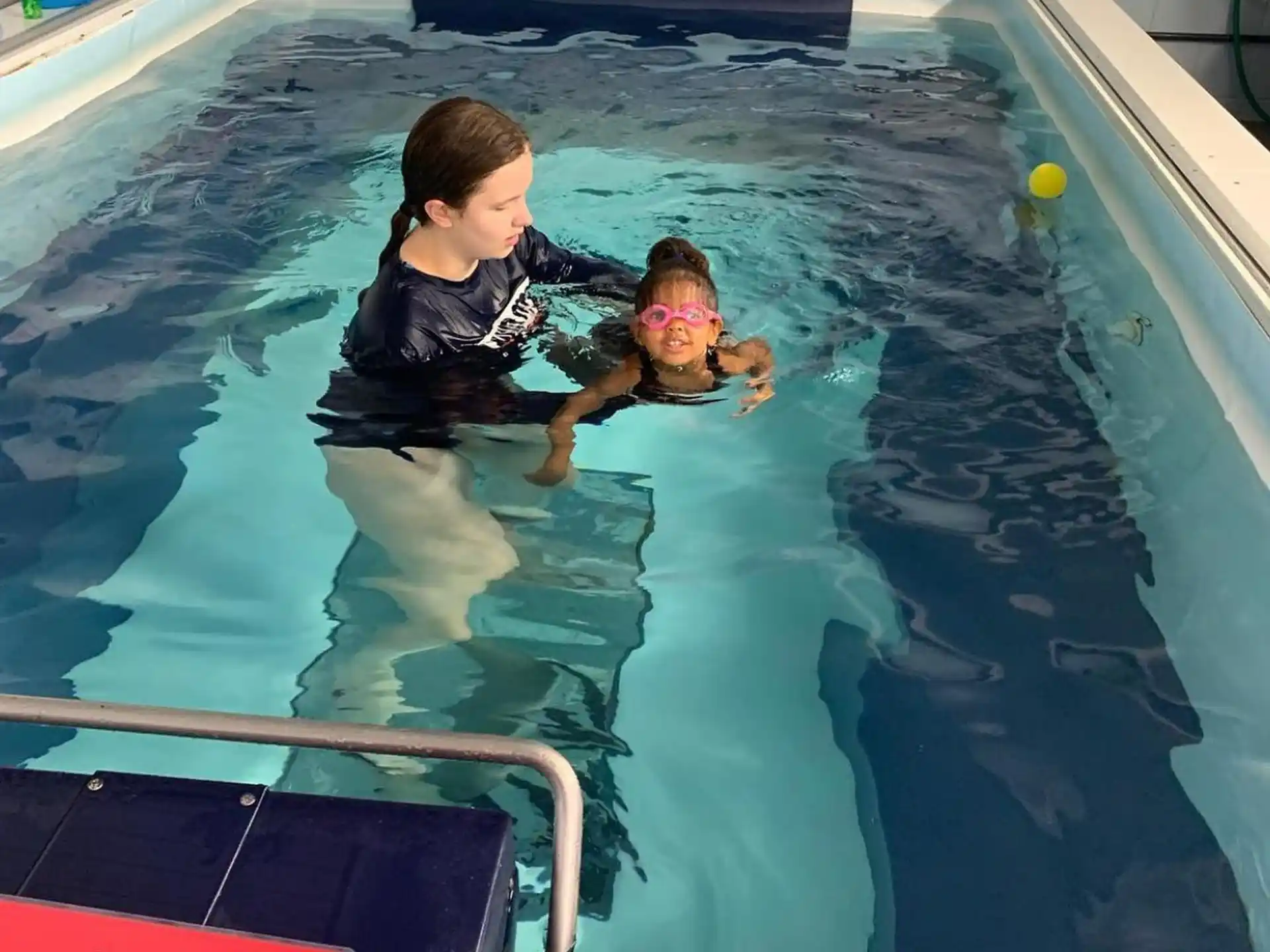 a person and two children in a pool