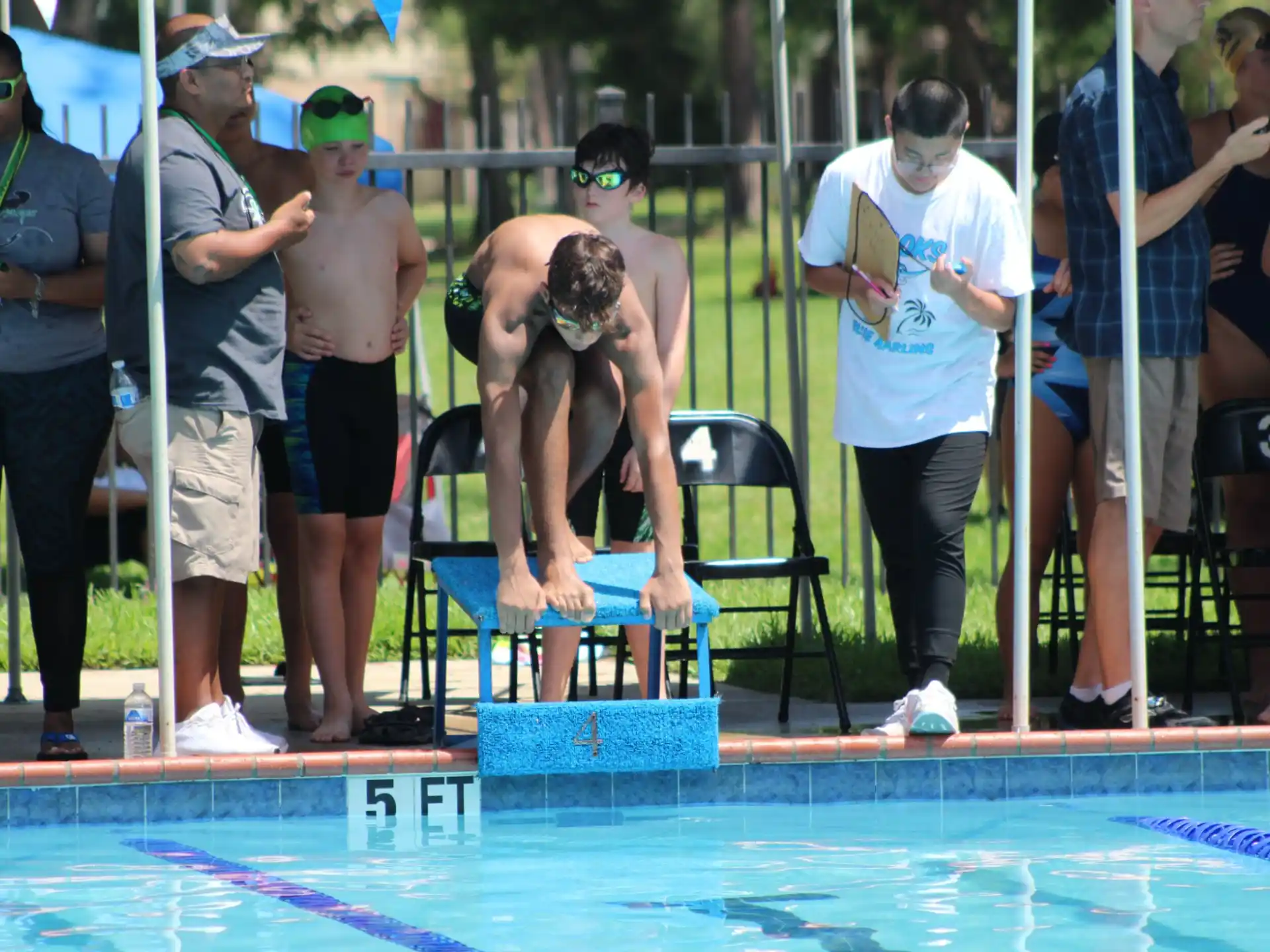 a person sitting on a chair in a pool with a crowd watching