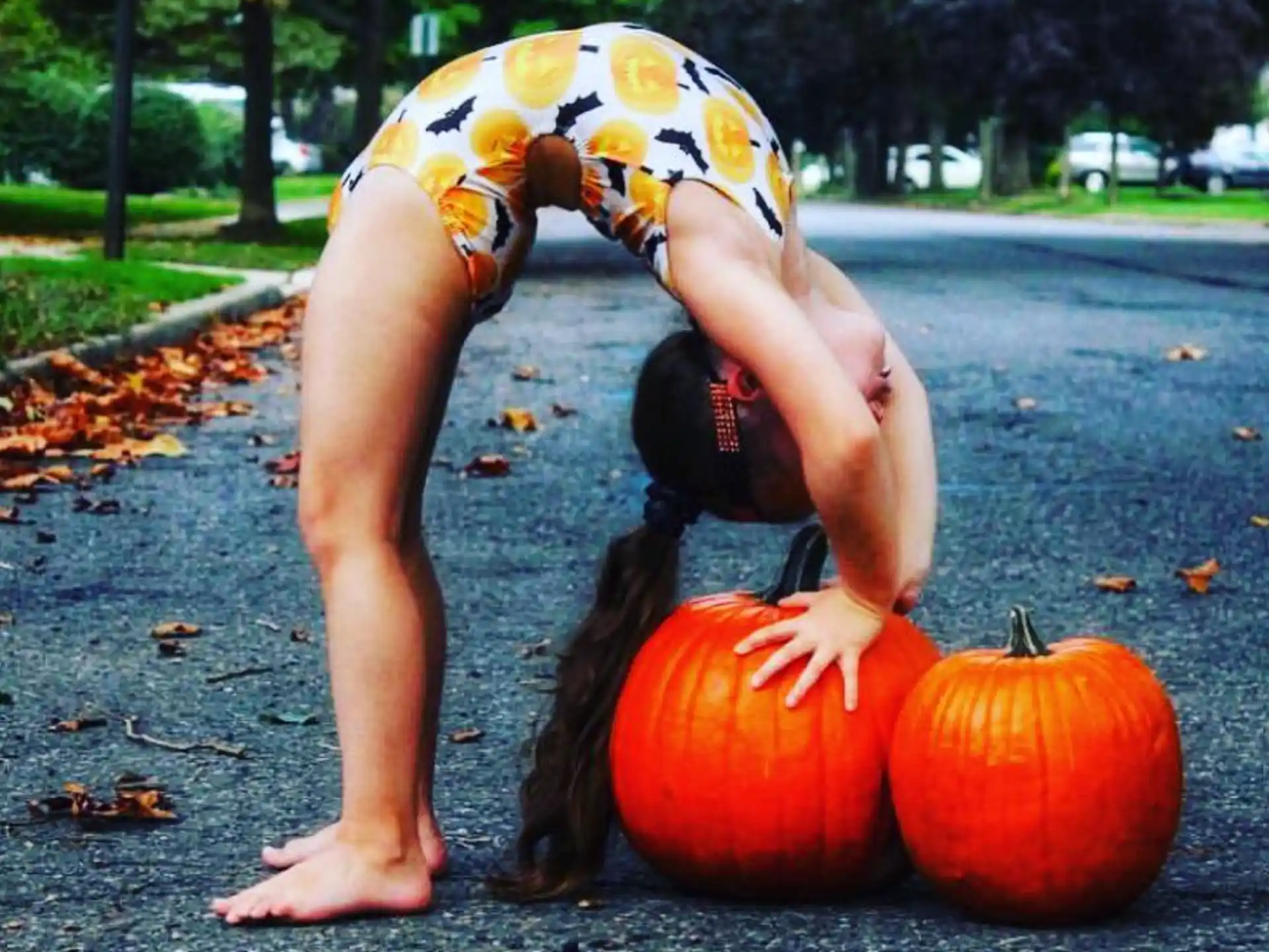 a girl with a bucket on her head and a pumpkin in front of her