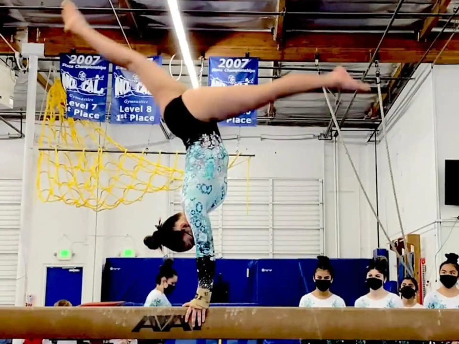 a person doing a handstand on a mat in a gym