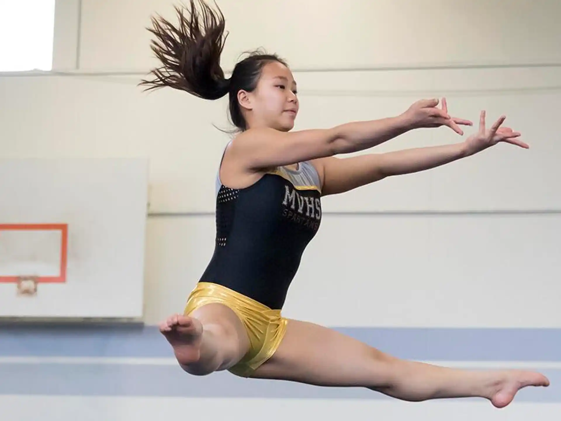 a woman in a leotard doing a handstand