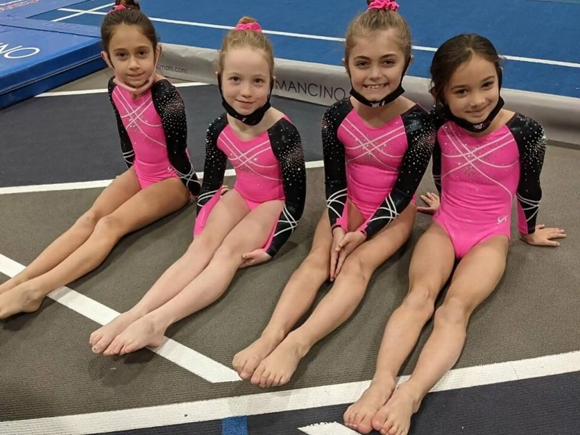 a group of girls in leotards on a track