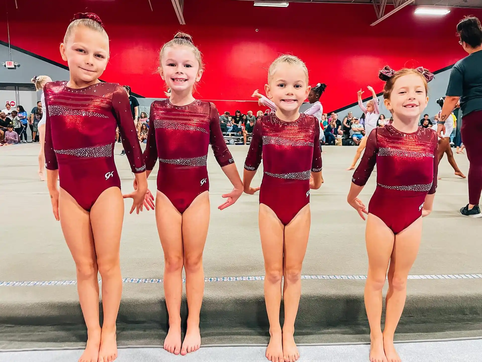 a group of girls in leotards posing for a photo